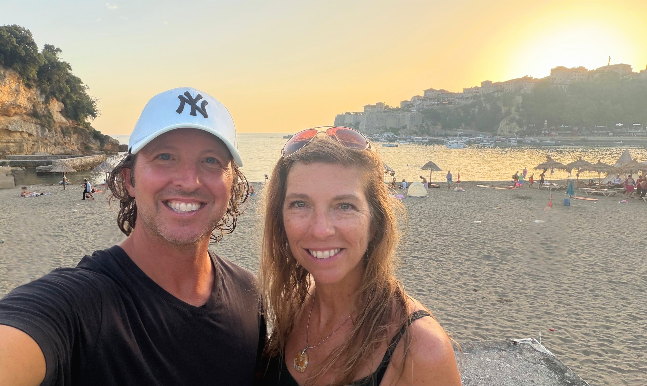 Sam and Stephanie above Mala Plaža at sunset with Ulcinj Old Town behind them.