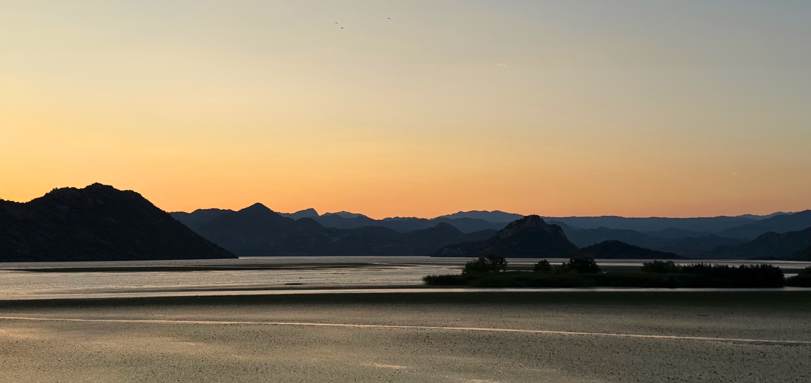 Lake Skadar from the train with mountains beyond the water