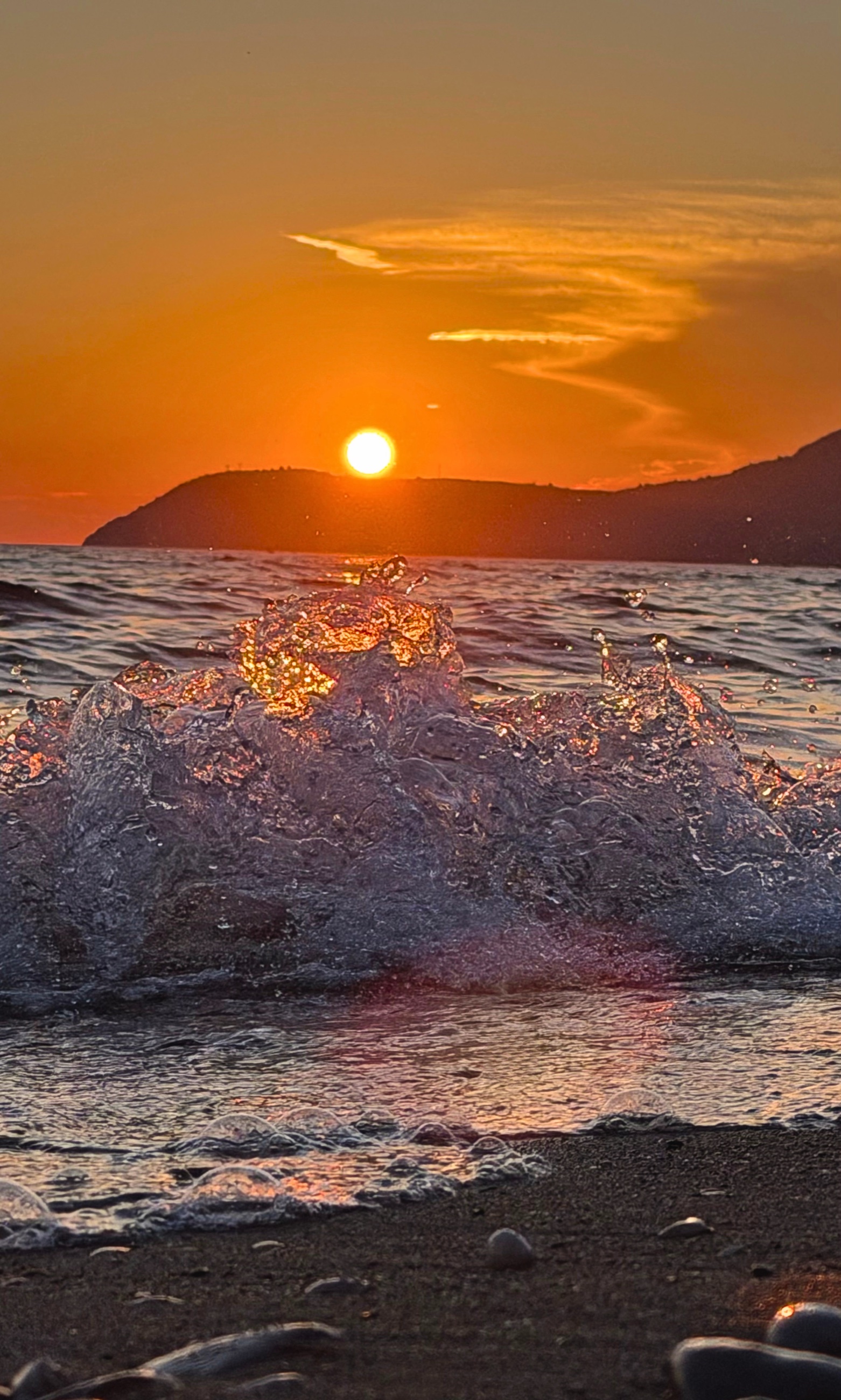 A wave splashing in the last evening light along Bar’s shoreline
