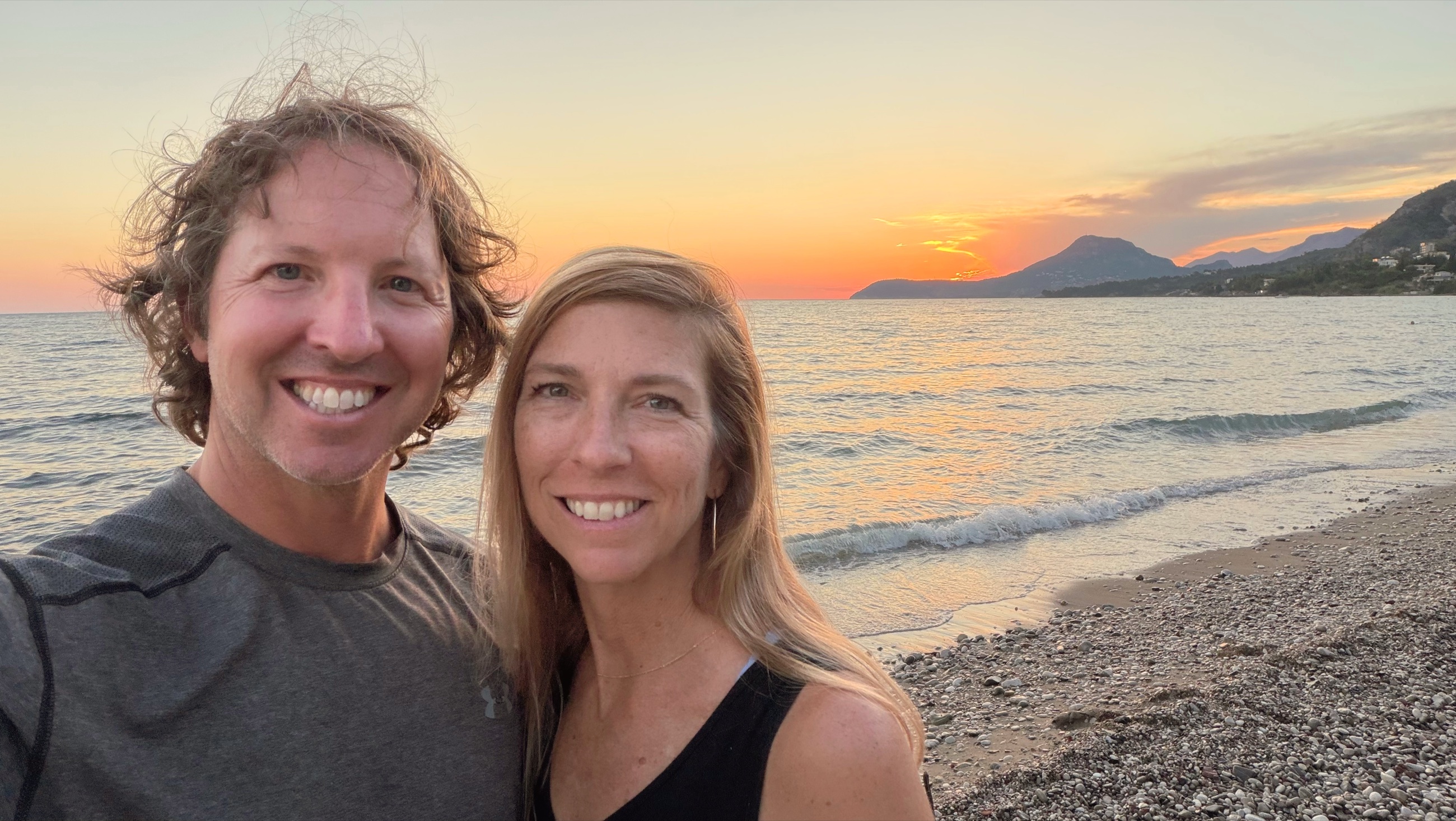 Sam and Stephanie seated on the beach in Šušanj at sunset