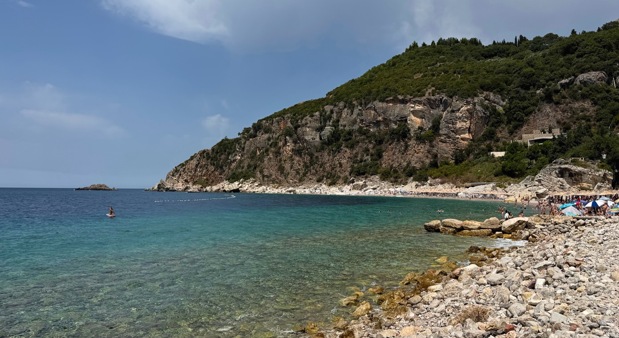 Perazića Do Beach beneath steep green slopes on Montenegro's Adriatic coast.