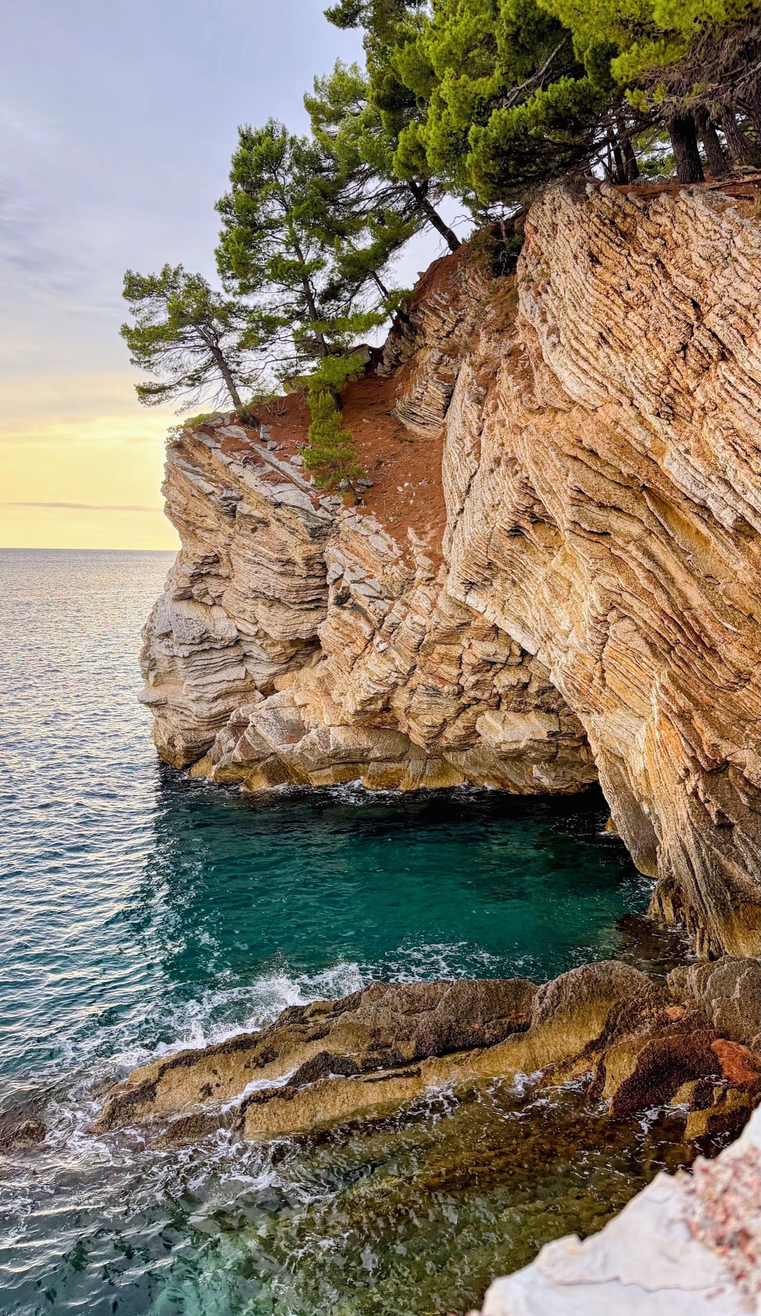 Folded limestone cliffs enclosing a small cove along the Health Trail north of Petrovac.
