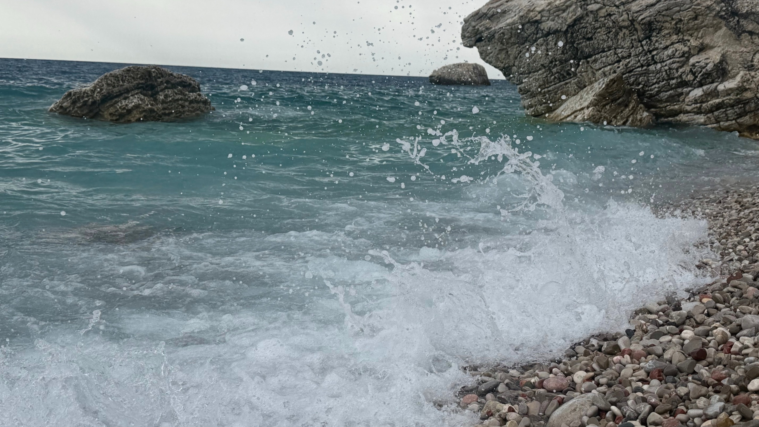 A wave breaking over the pebble shoreline at Perazića Do.