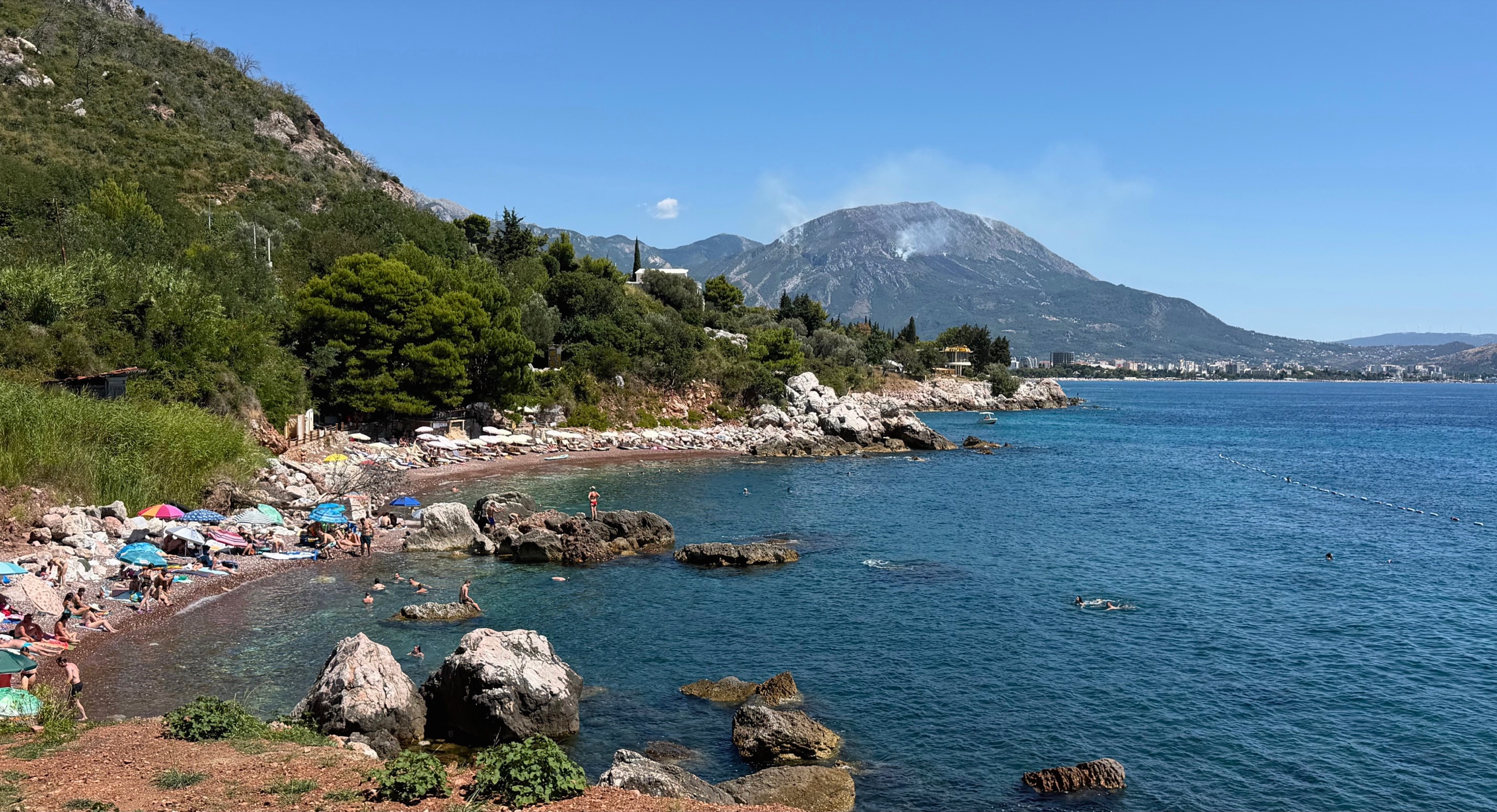 Red Beach near Šušanj with reddish pebbles, rocky coves, and clear blue water.