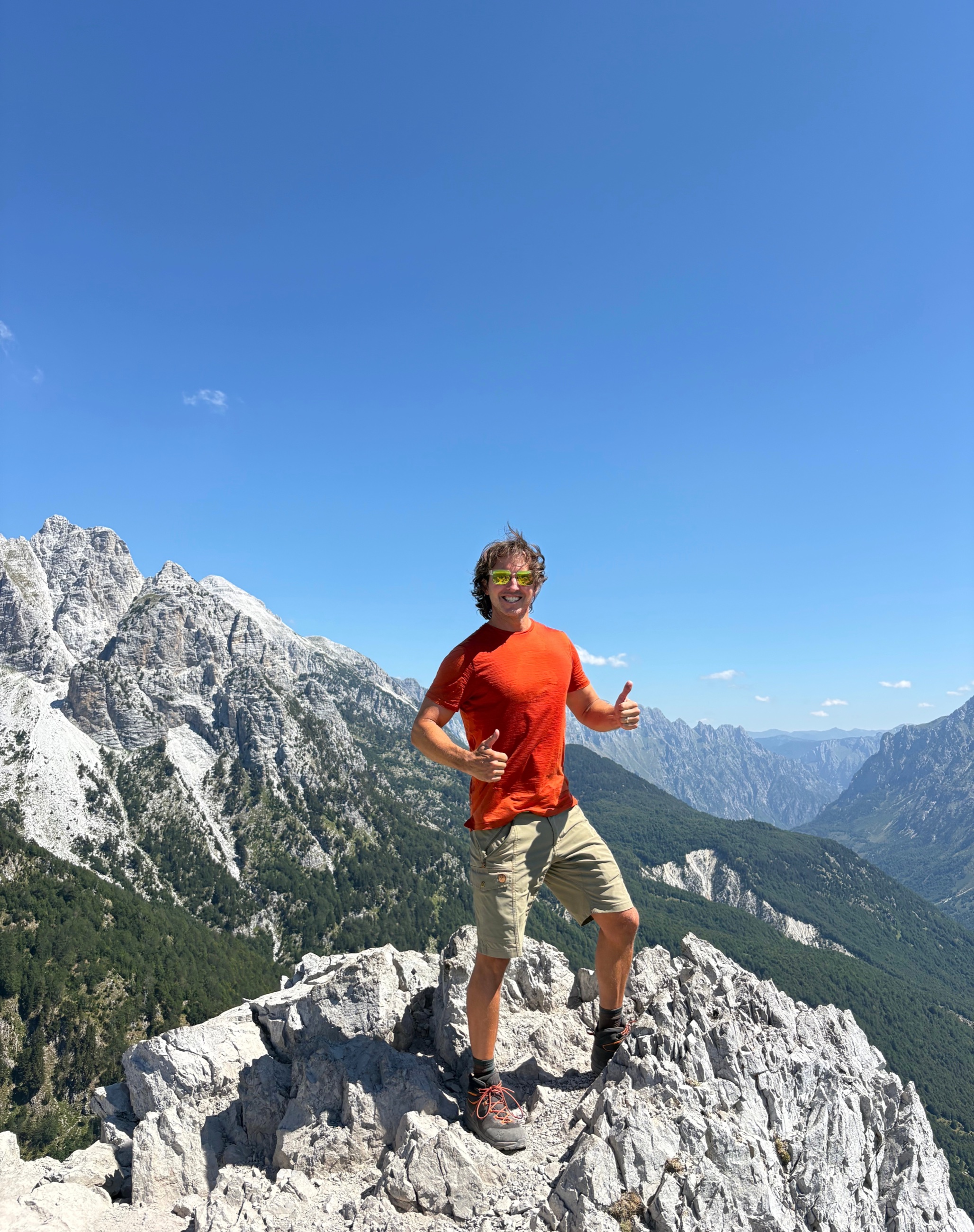 Sam standing on a rocky peak high above the valleys between Valbona and Theth.