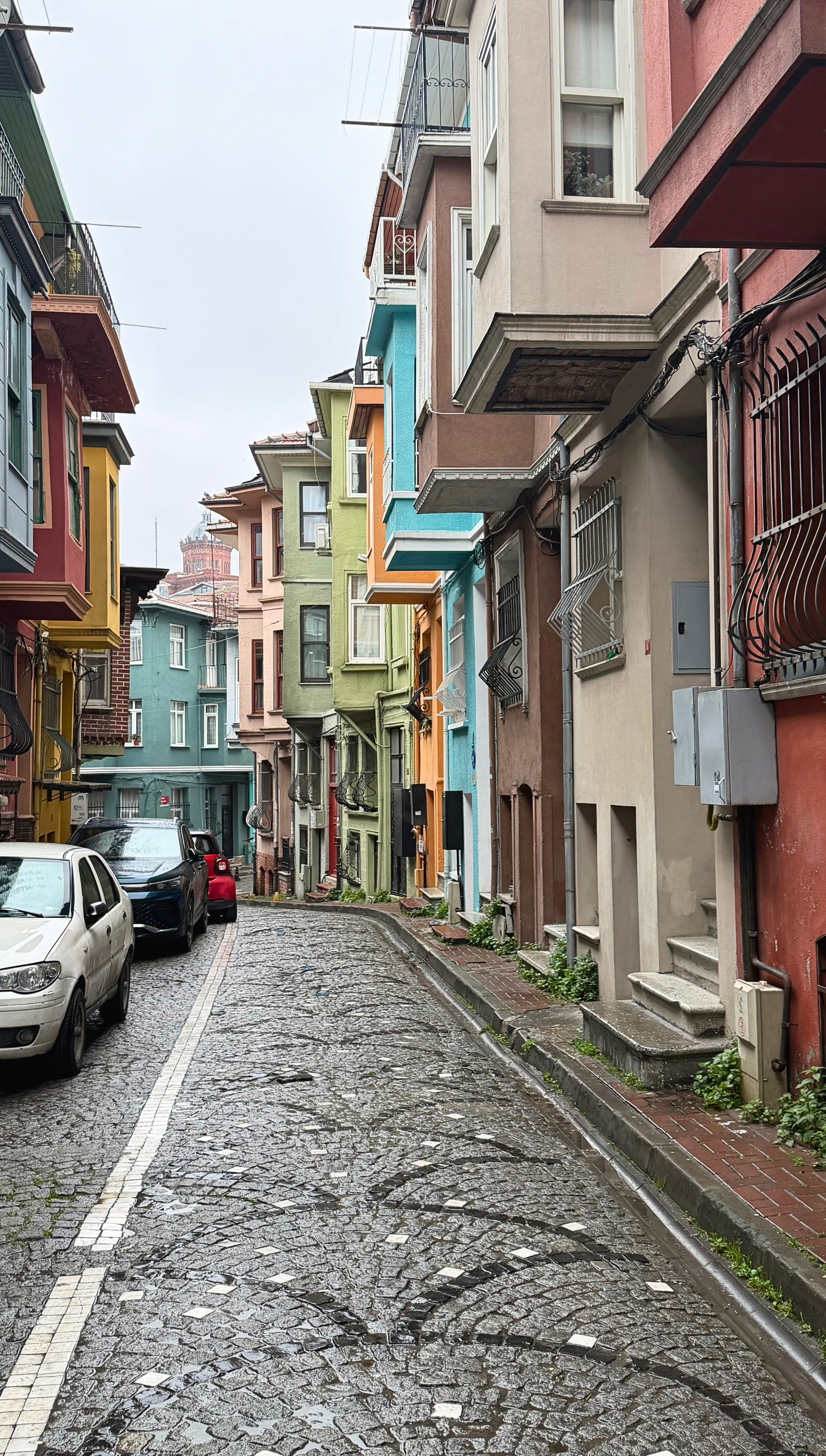 A colorful narrow side street in Balat with painted houses and cobblestones.