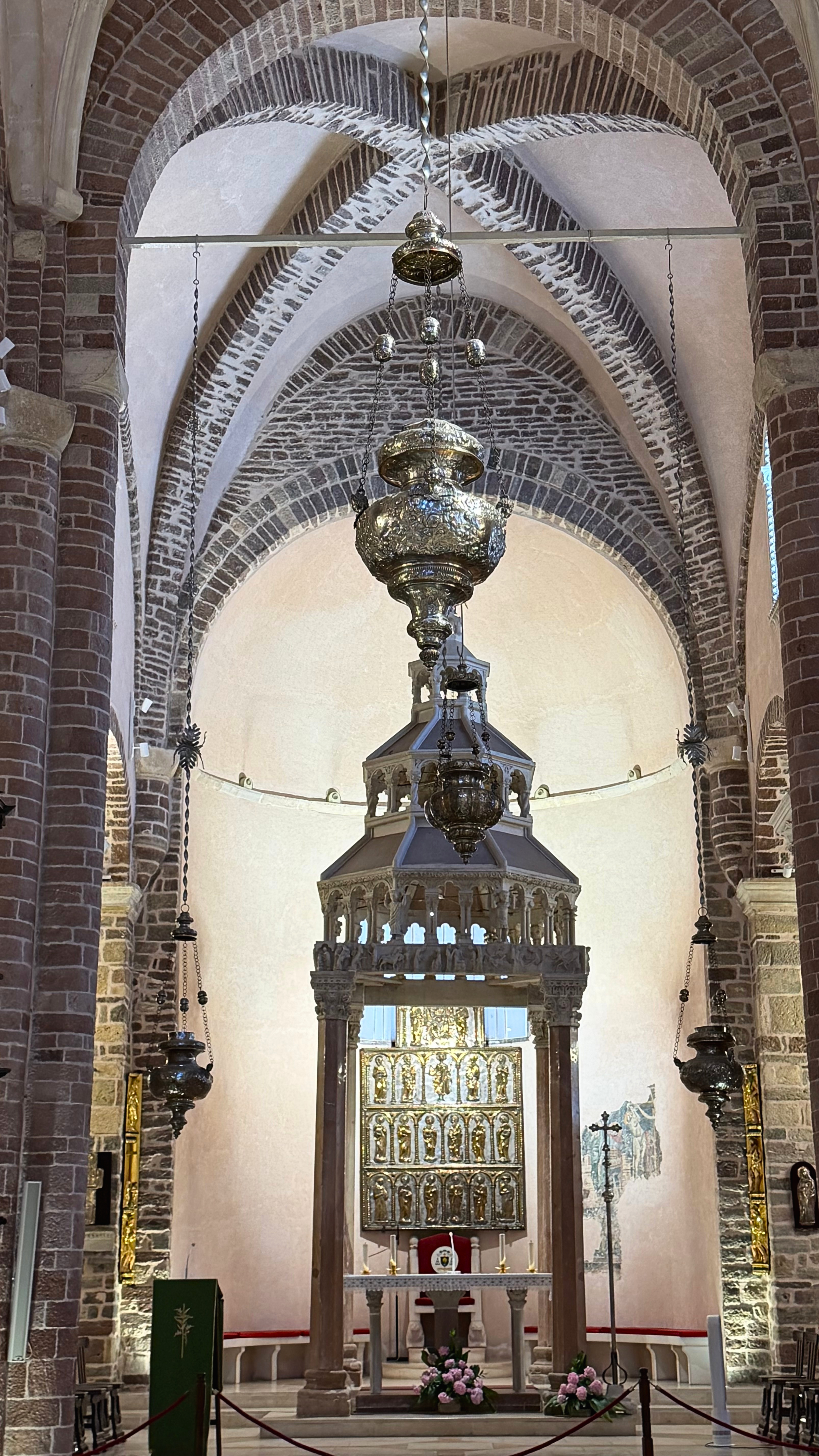 Inside St. Tryphon Cathedral, stone columns and vaulted brickwork rising toward the silver-gilt altar screen.