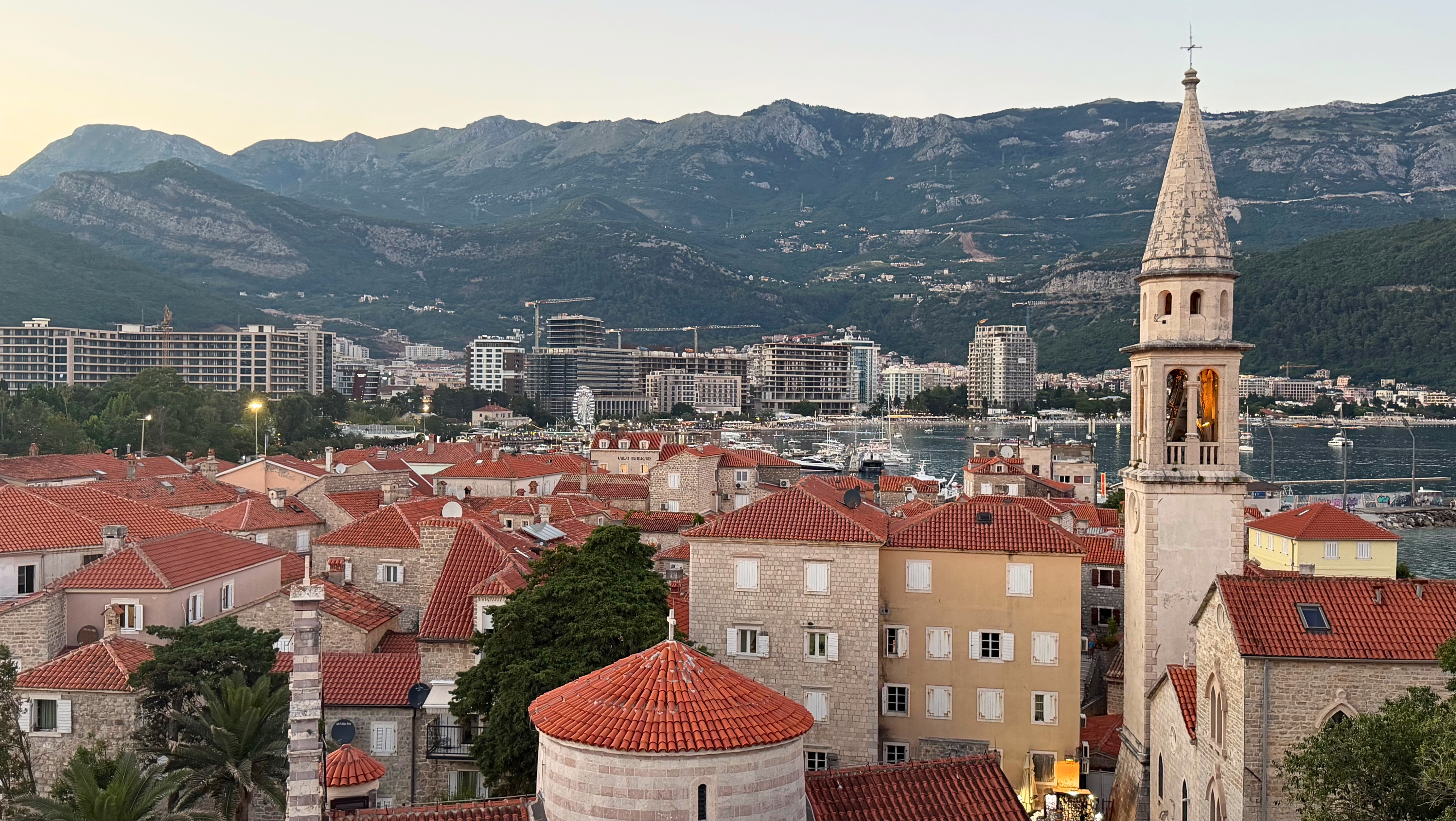 Budva seen from the Citadel, with the old town in the foreground and modern Budva beyond as evening arrives over the coast