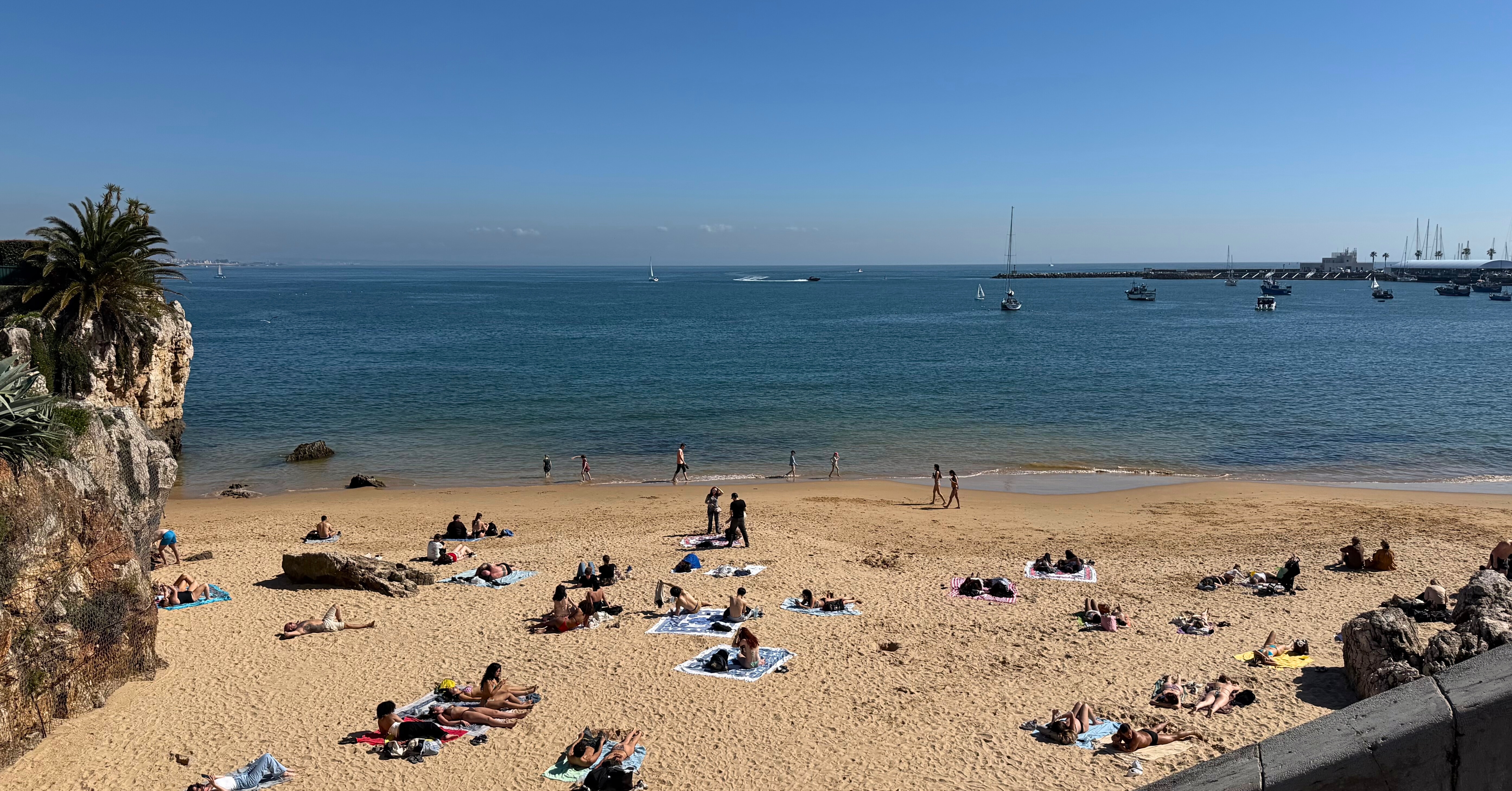 Praia da Rainha in Cascais with a small sandy beach tucked between rocky cliffs.