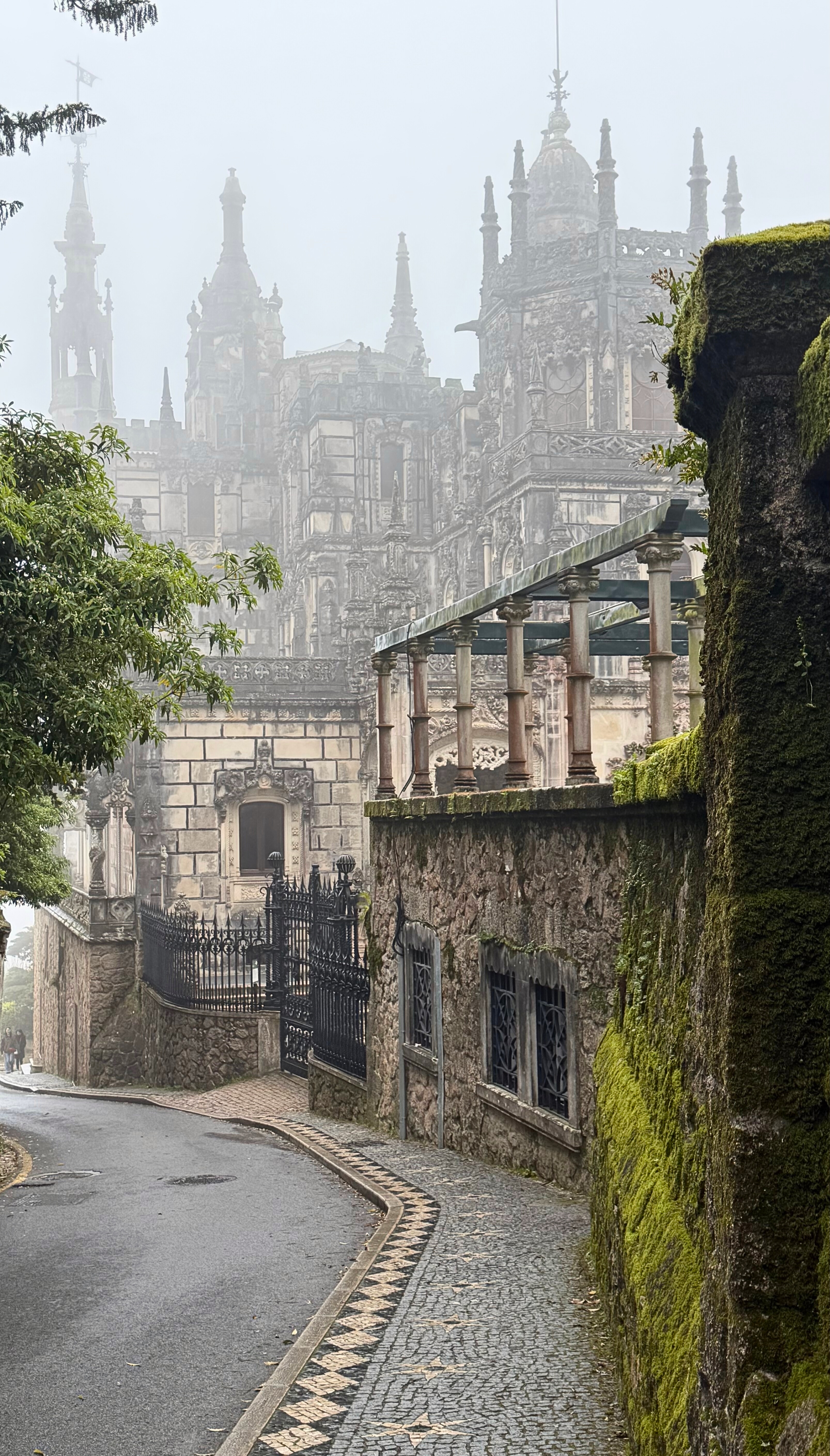 Quinta da Regaleira in Sintra seen through mist and trees.