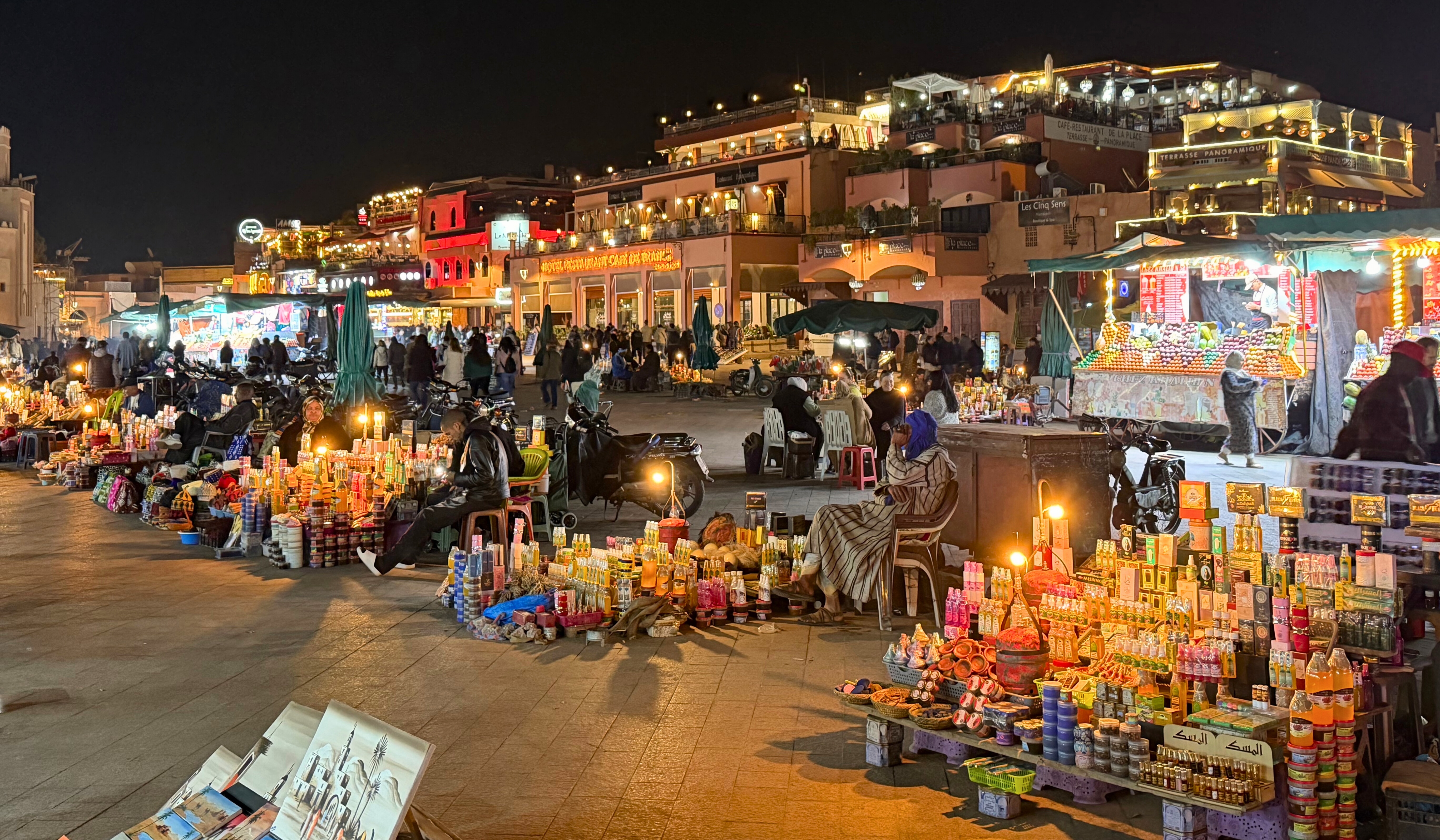 Jemaa el-Fnaa in Marrakesh after dark, with crowds, lights, and food stalls filling the public square.