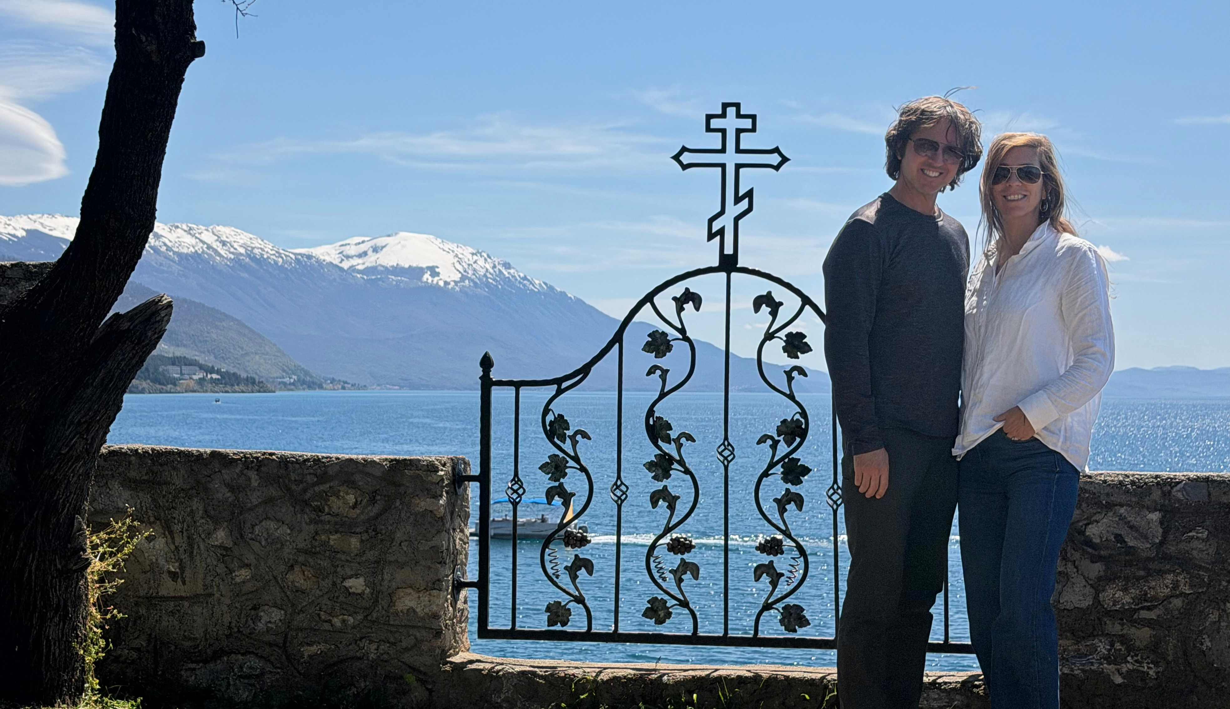 Sam and Stephanie standing by a church gate overlooking Lake Ohrid.
