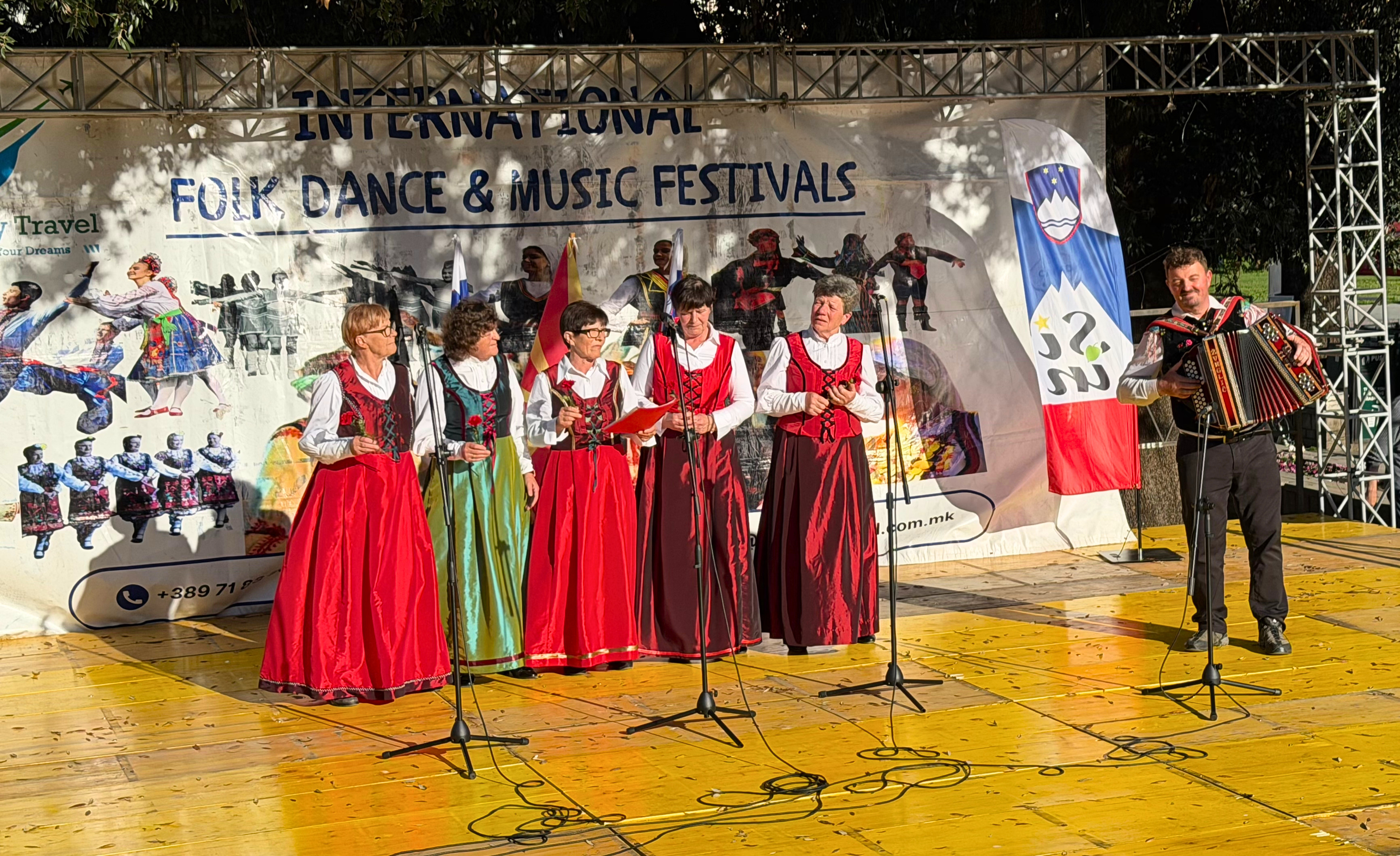 Traditional singers and an accordion player performing on an outdoor stage during a folk festival in Ohrid.