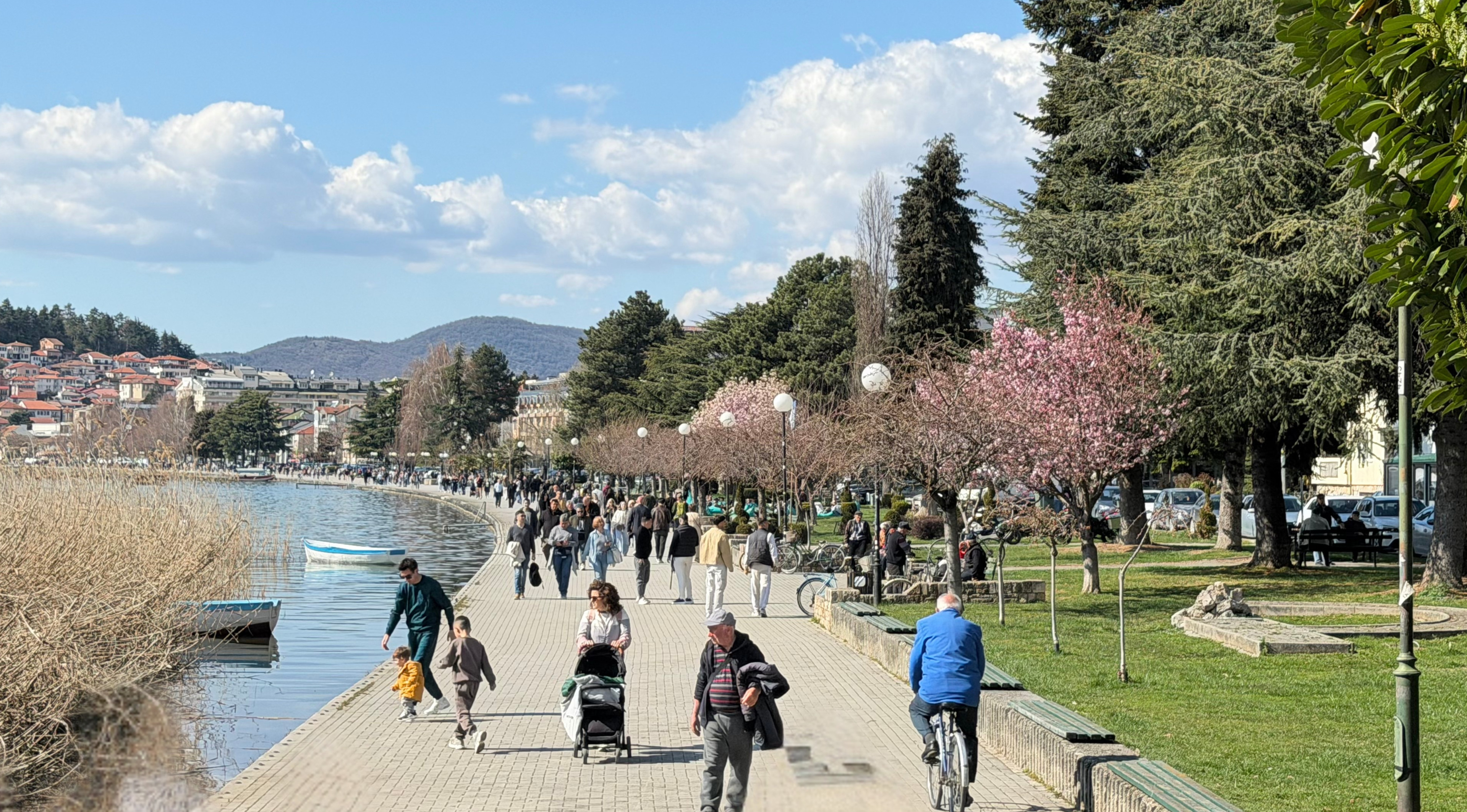 People walking along Ohrid's lakeside promenade during daily life near the water.