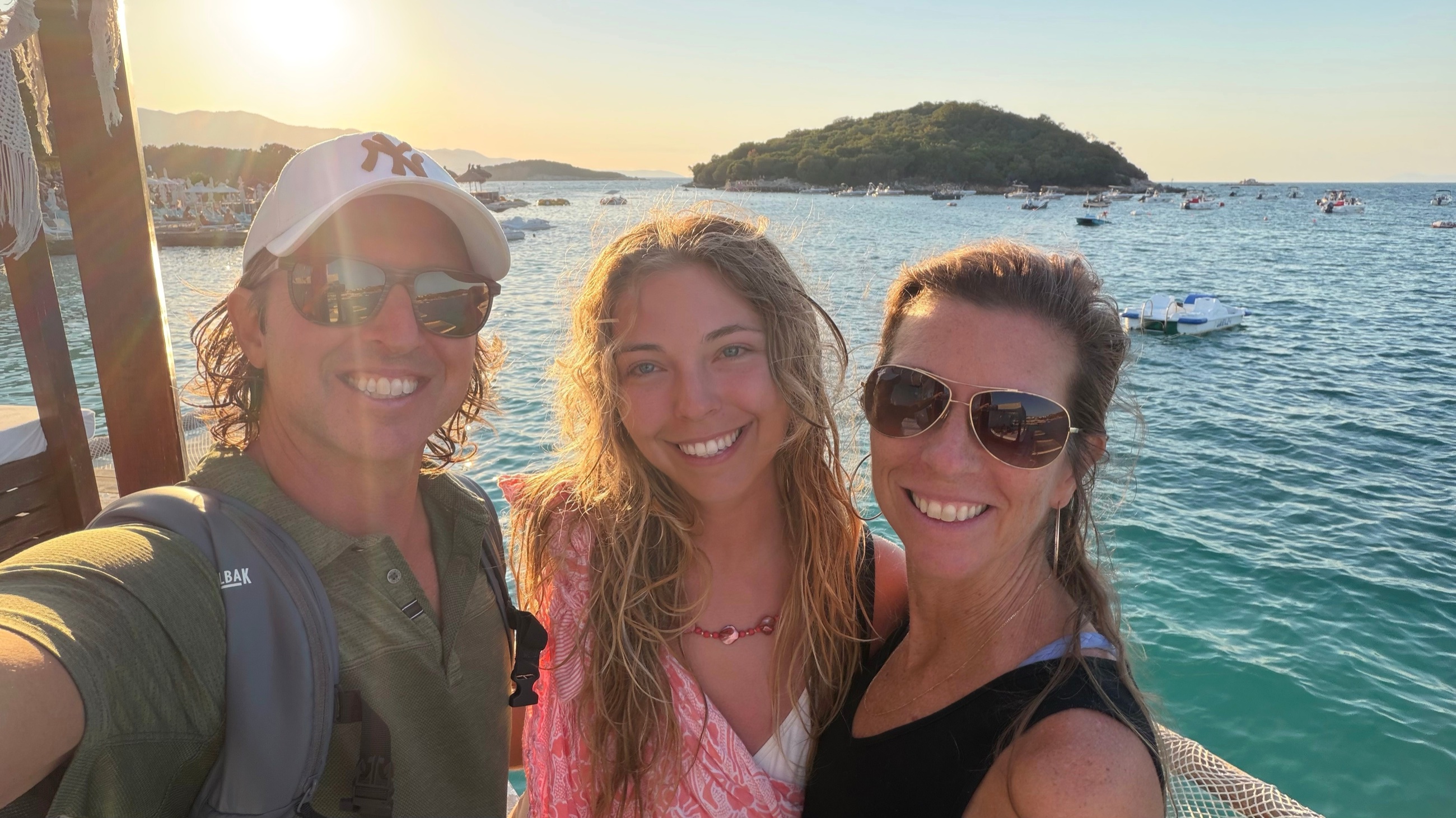 Sam, Bailey, and Stephanie together beside the water at Ksamil near sunset.