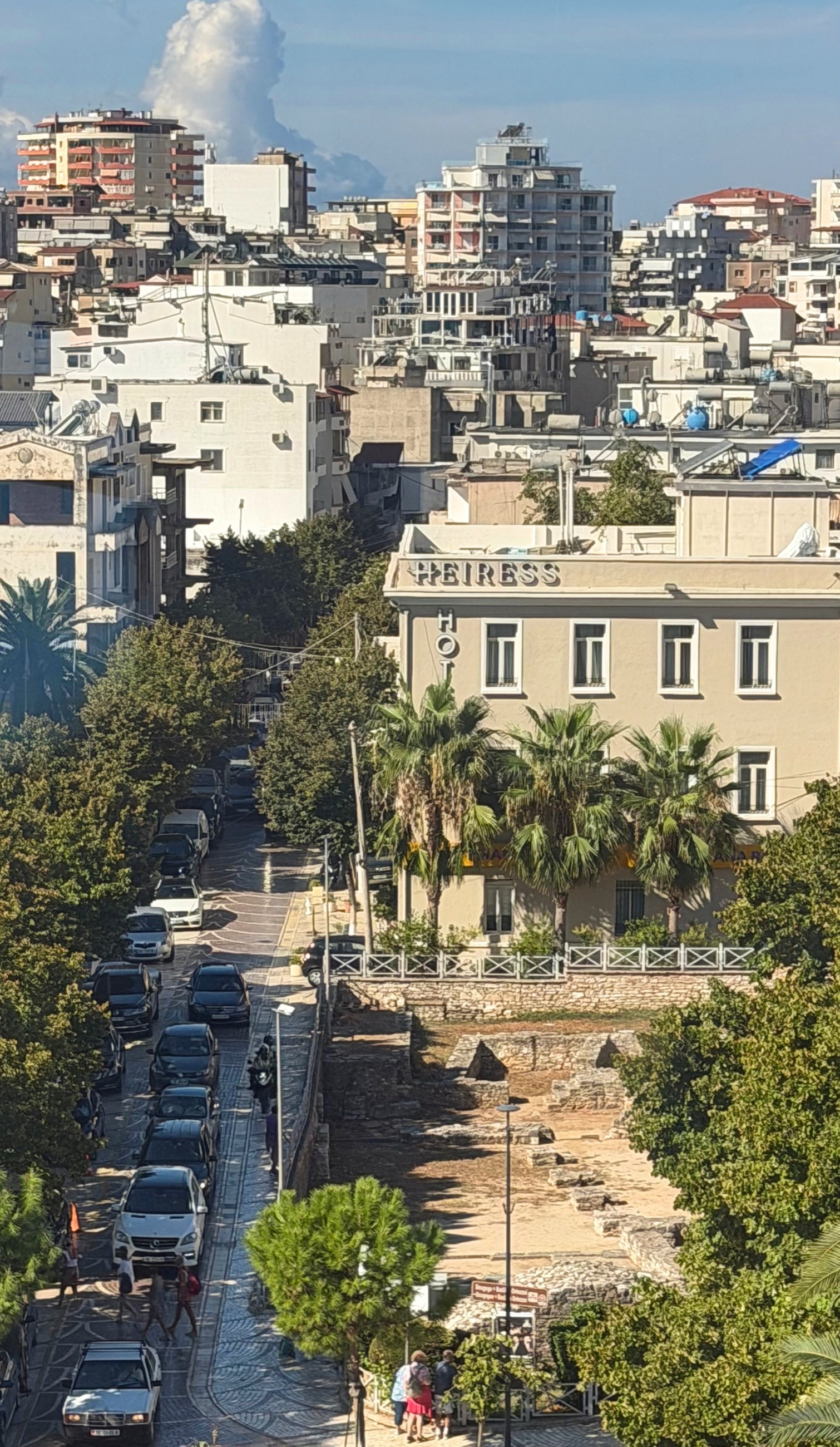 The synagogue-basilica foundations seen from above between Sarandë streets and buildings.