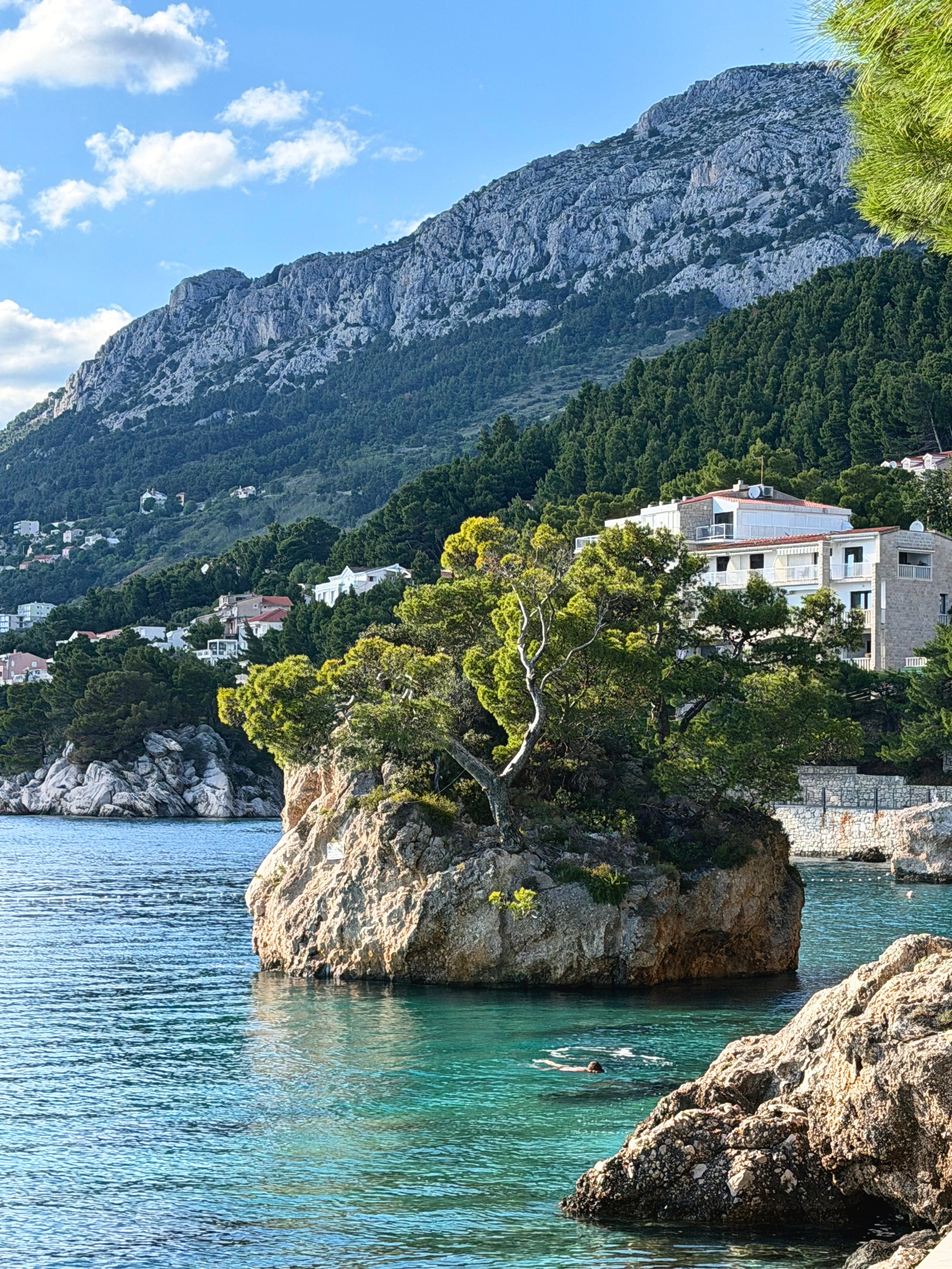 The Rock of Brela near Punta Rata with swimmers below and Biokovo behind