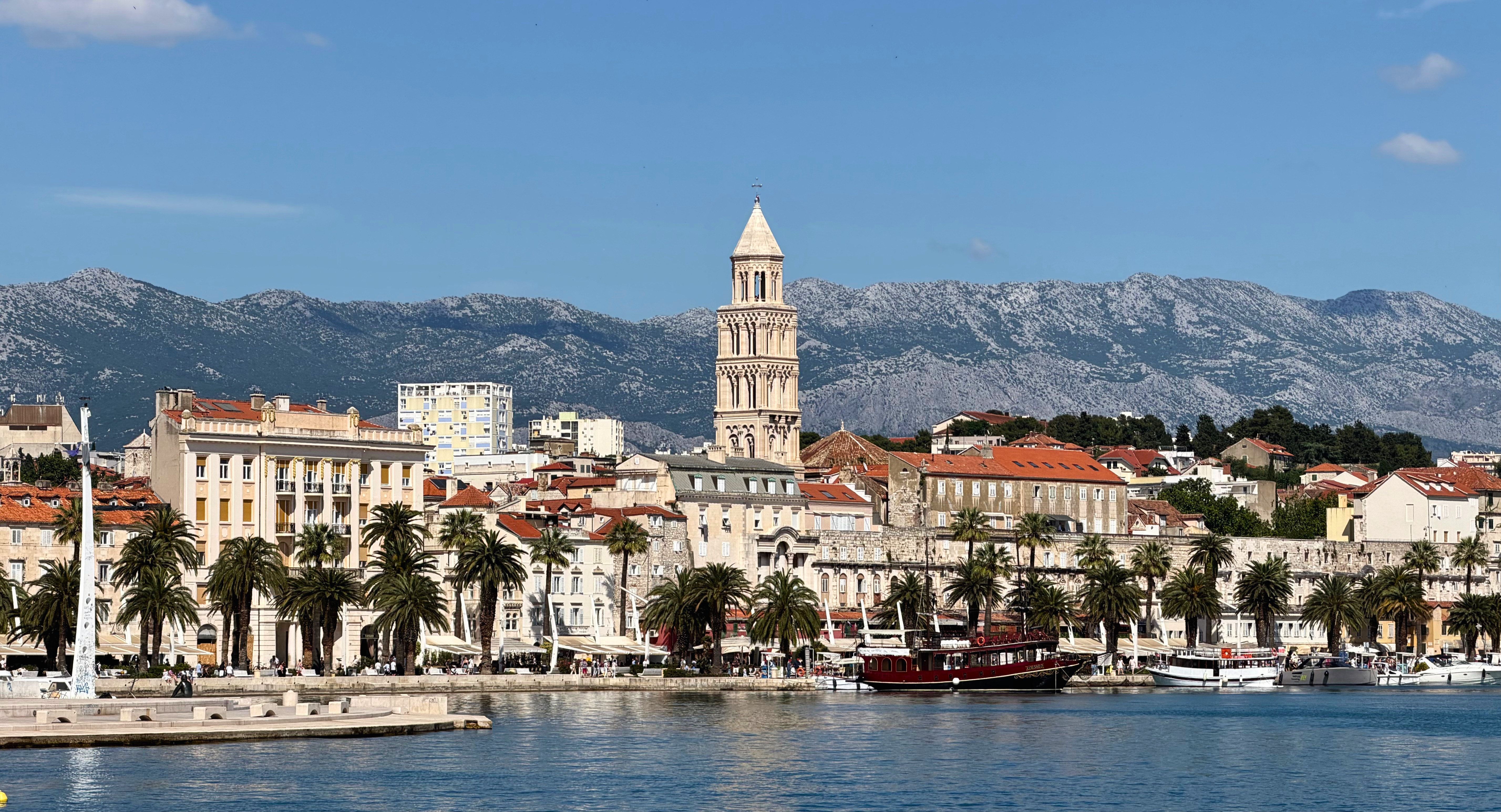 Split viewed from the water with the waterfront, palace, harbor, and mountains in one frame