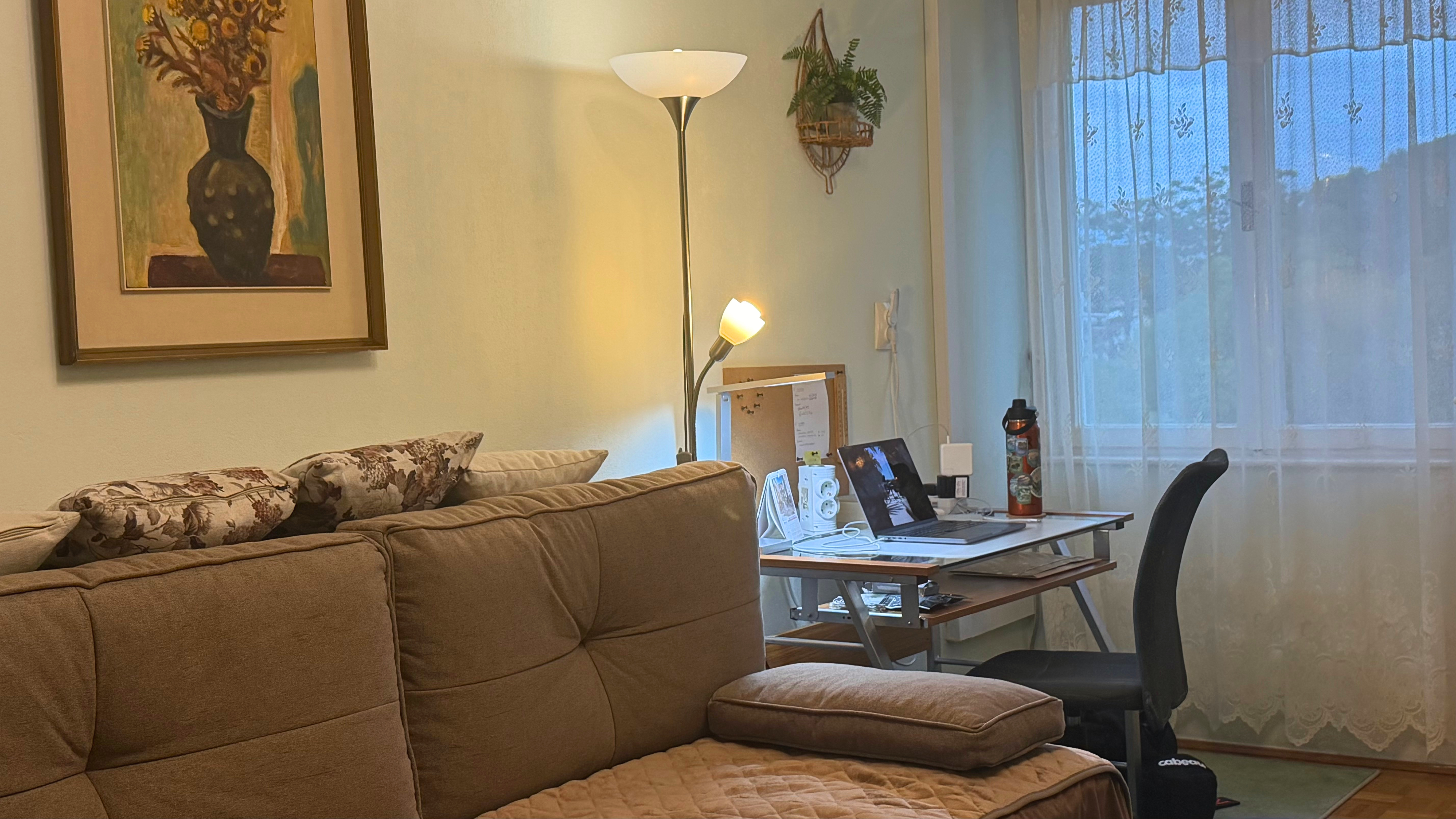 A Split apartment work setup with computer, router, supplies, and small personal touches arranged for a month-long stay.