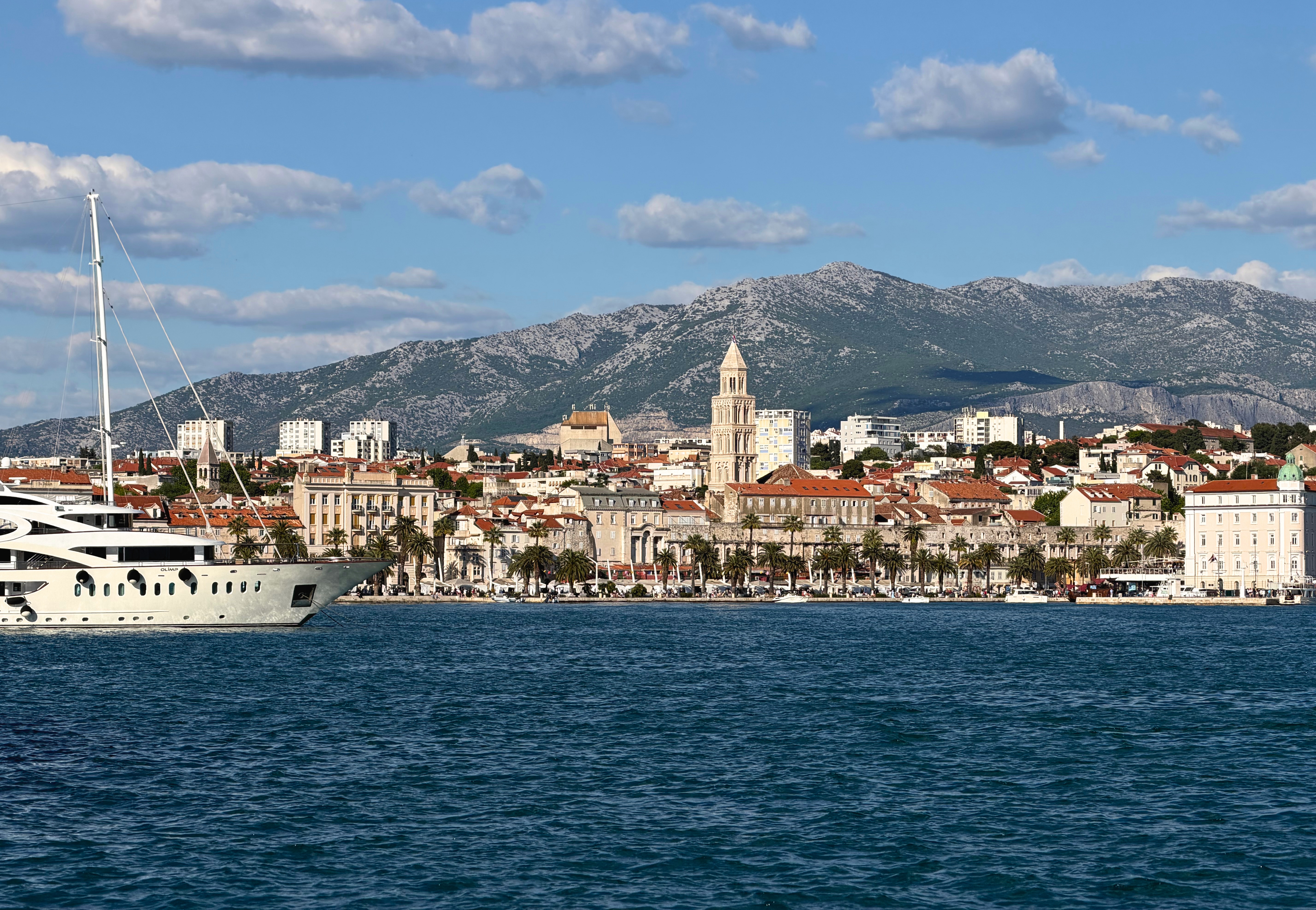 Split harbor with the Adriatic Sea in front of the city and mountains rising behind it.