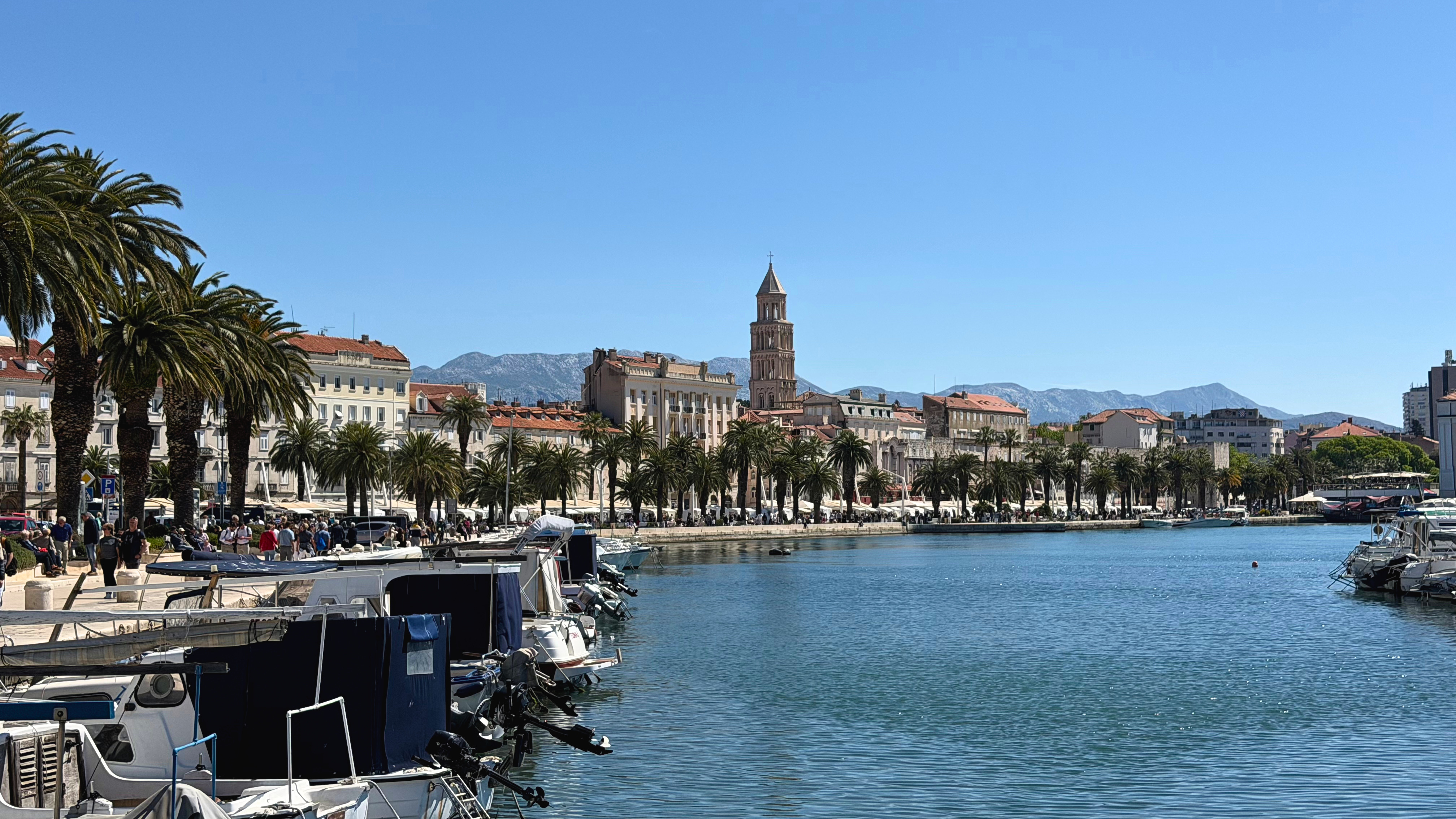 The Riva waterfront promenade in Split, lined with palm trees and old stone buildings.