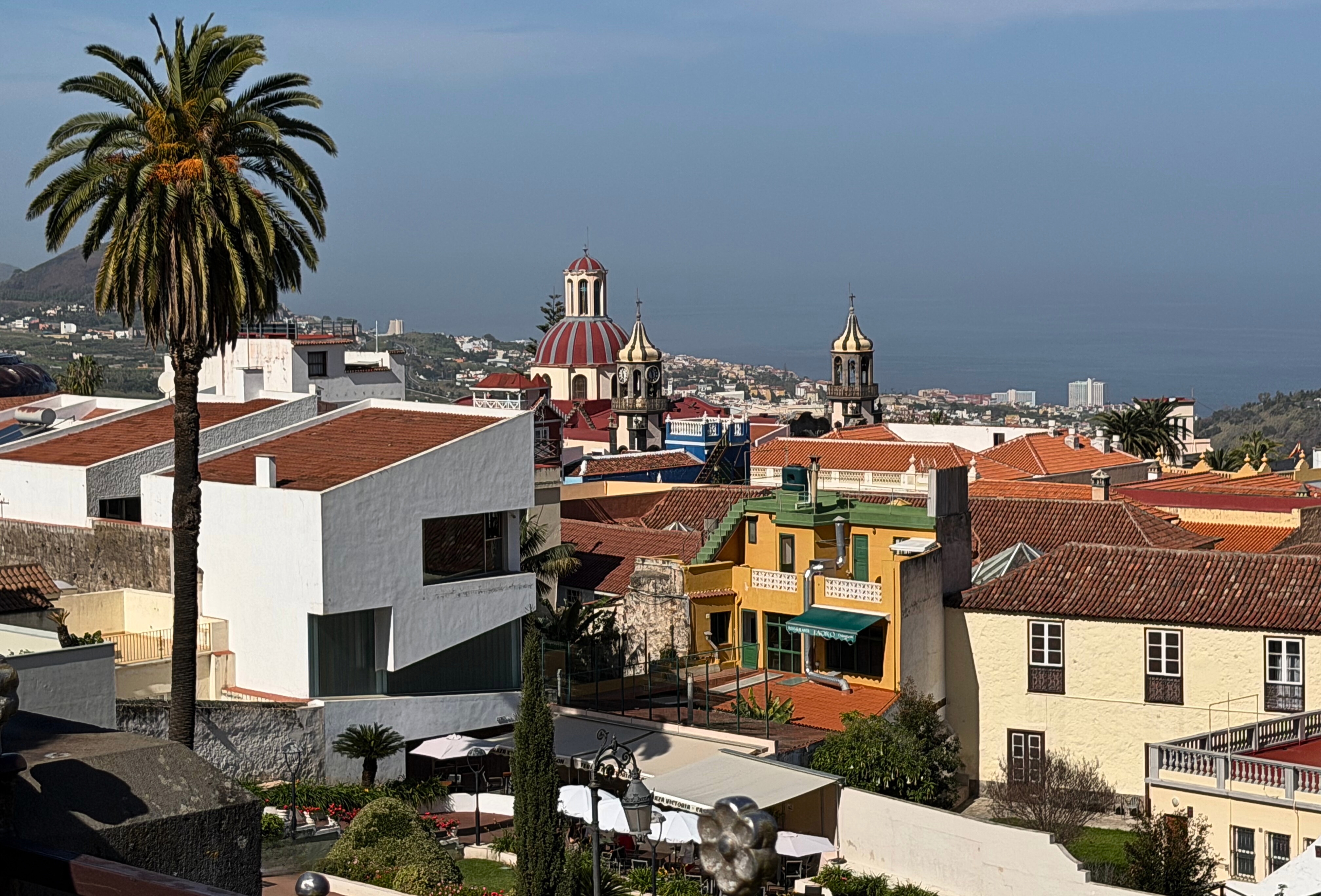 La Orotava rooftops, church towers, and the Atlantic Ocean in the distance.