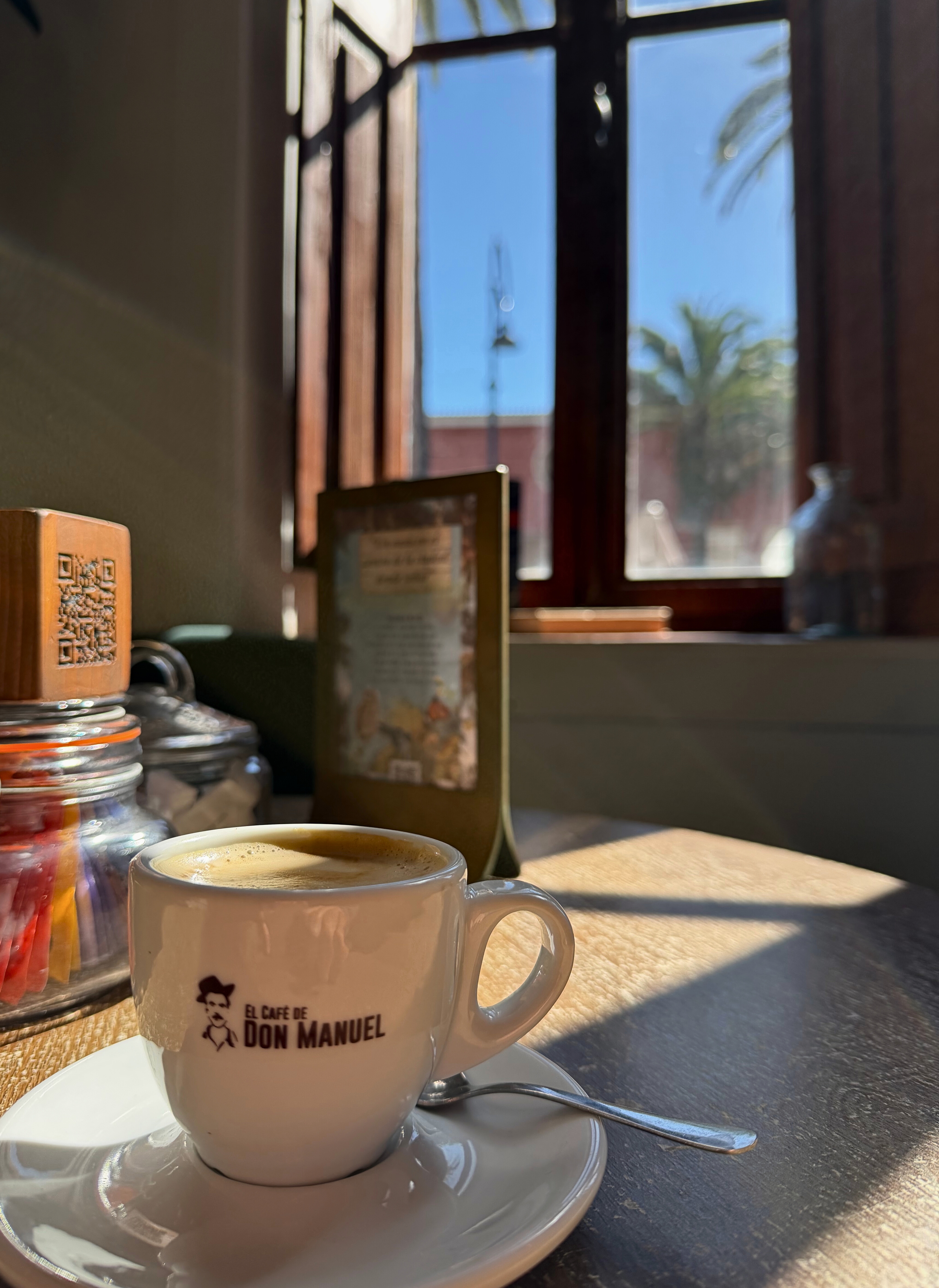 A cortado on a café table beside an open window in Tenerife.