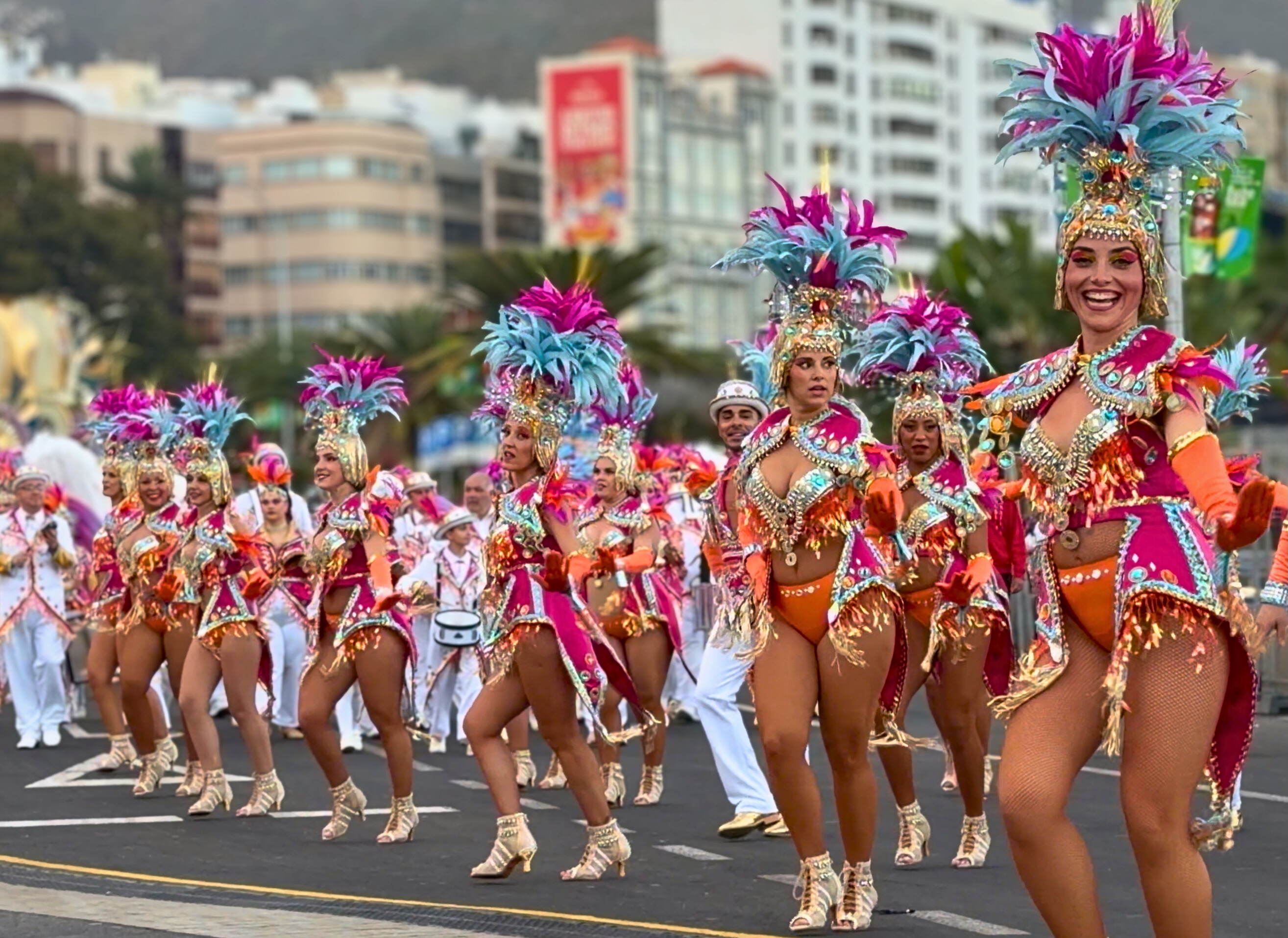 Comparsa dancers in bright Carnival costumes moving along the Santa Cruz parade route.