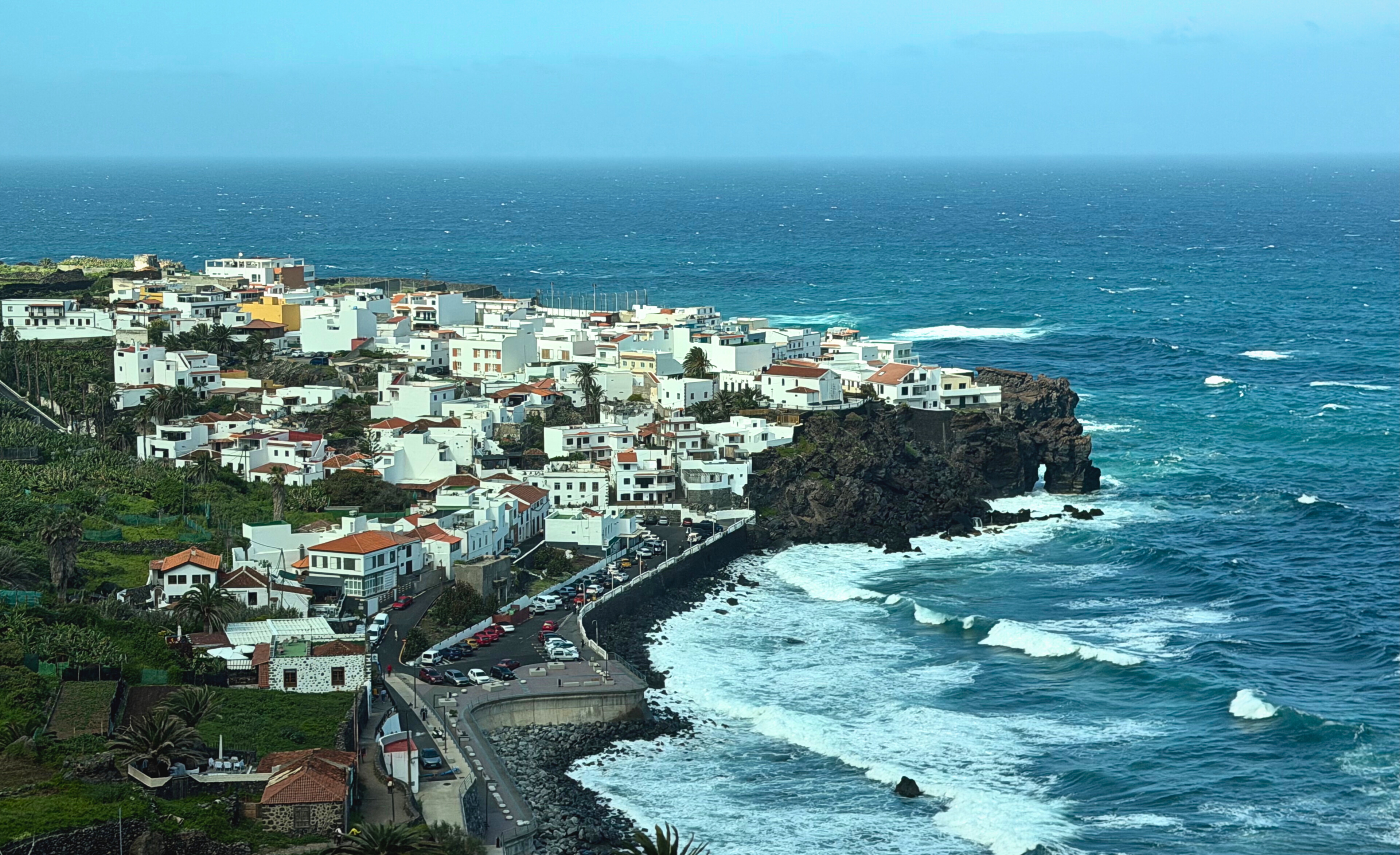 A coastal town and cliffs along Tenerife's north coast seen from above.