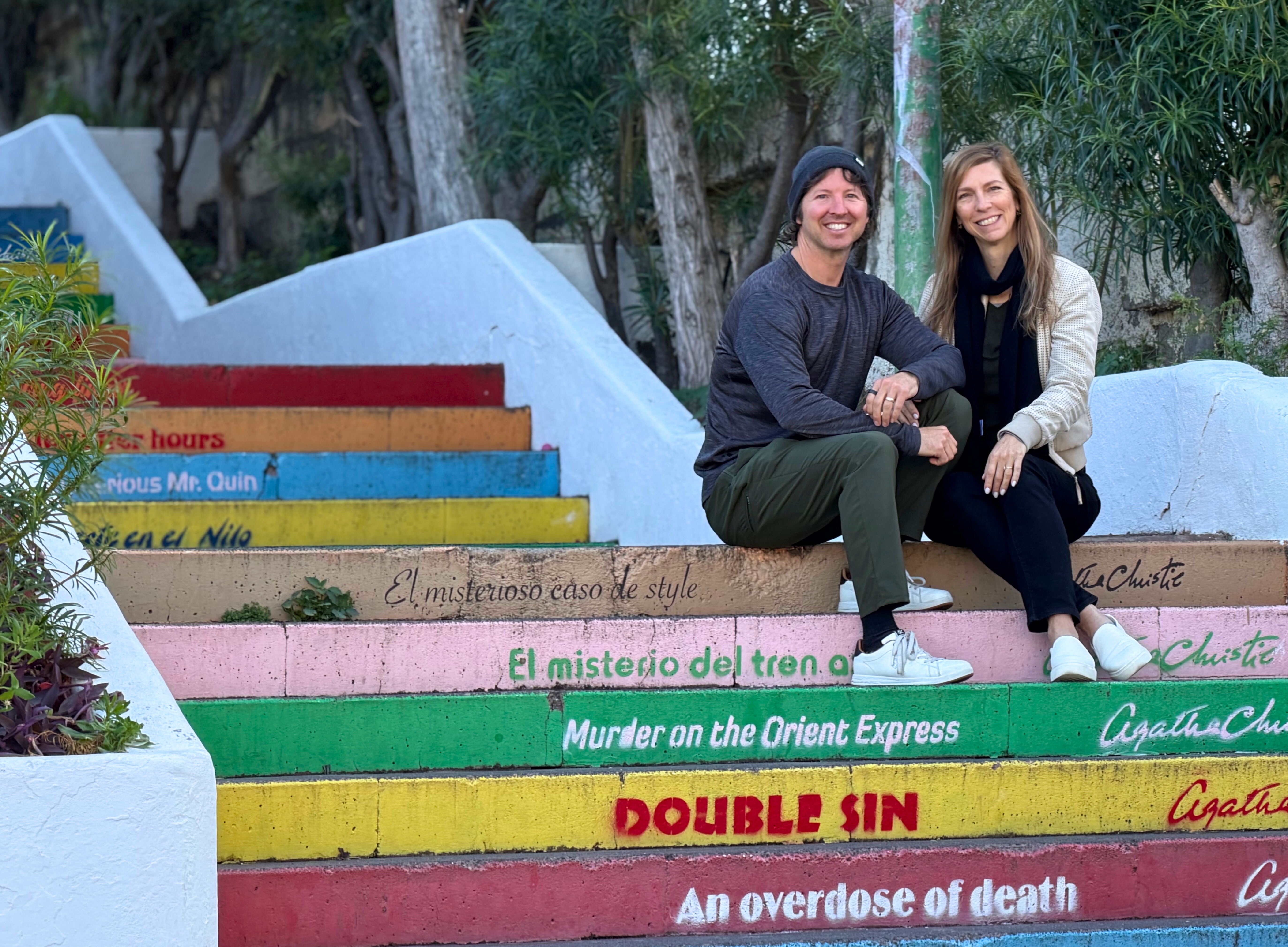 Sam and Stephanie sitting on the painted Agatha Christie steps in Puerto de la Cruz.