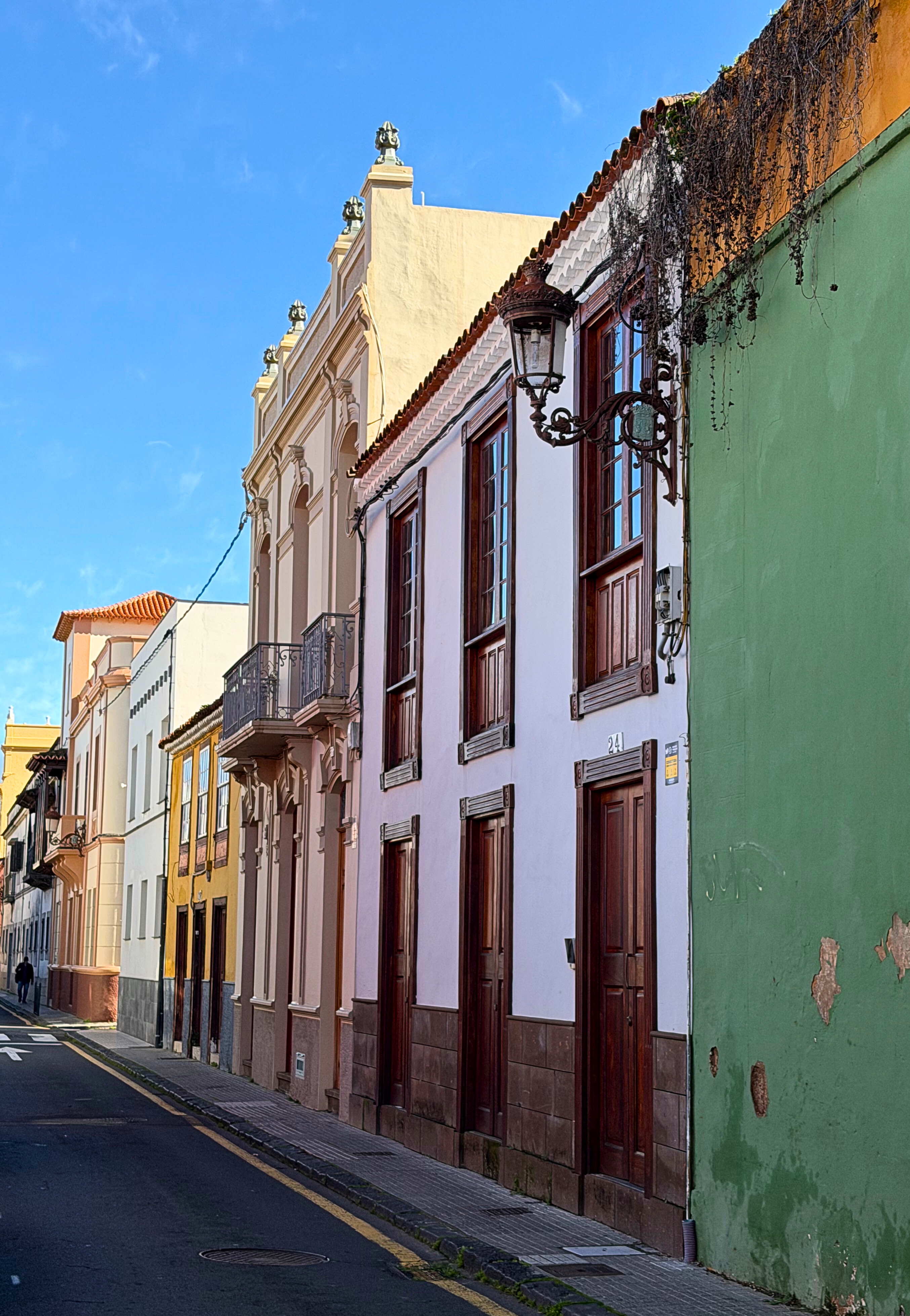 A quiet street in La Laguna’s historic grid with colorful facades and wooden doors.