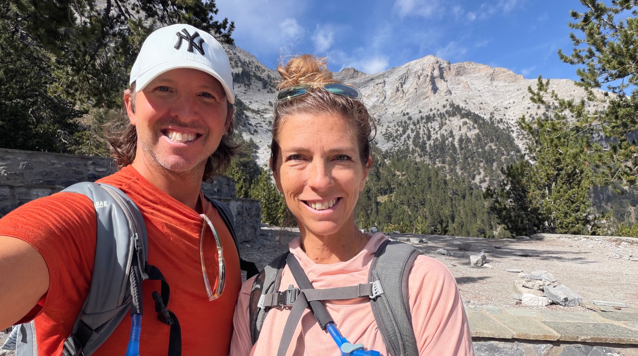 Sam and Stephanie hiking on Mount Olympus with limestone peaks behind them