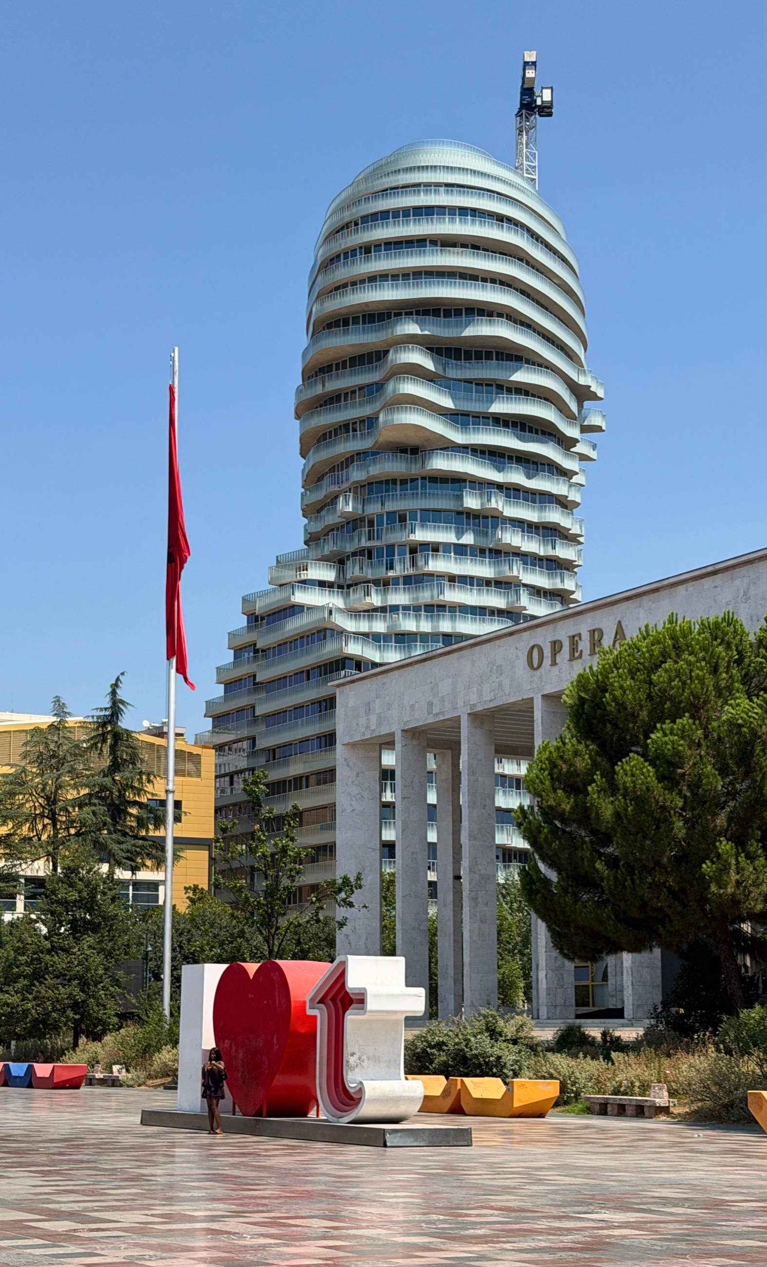 The National Theatre of Opera and Ballet on Skanderbeg Square with a contemporary high-rise tower rising behind it.