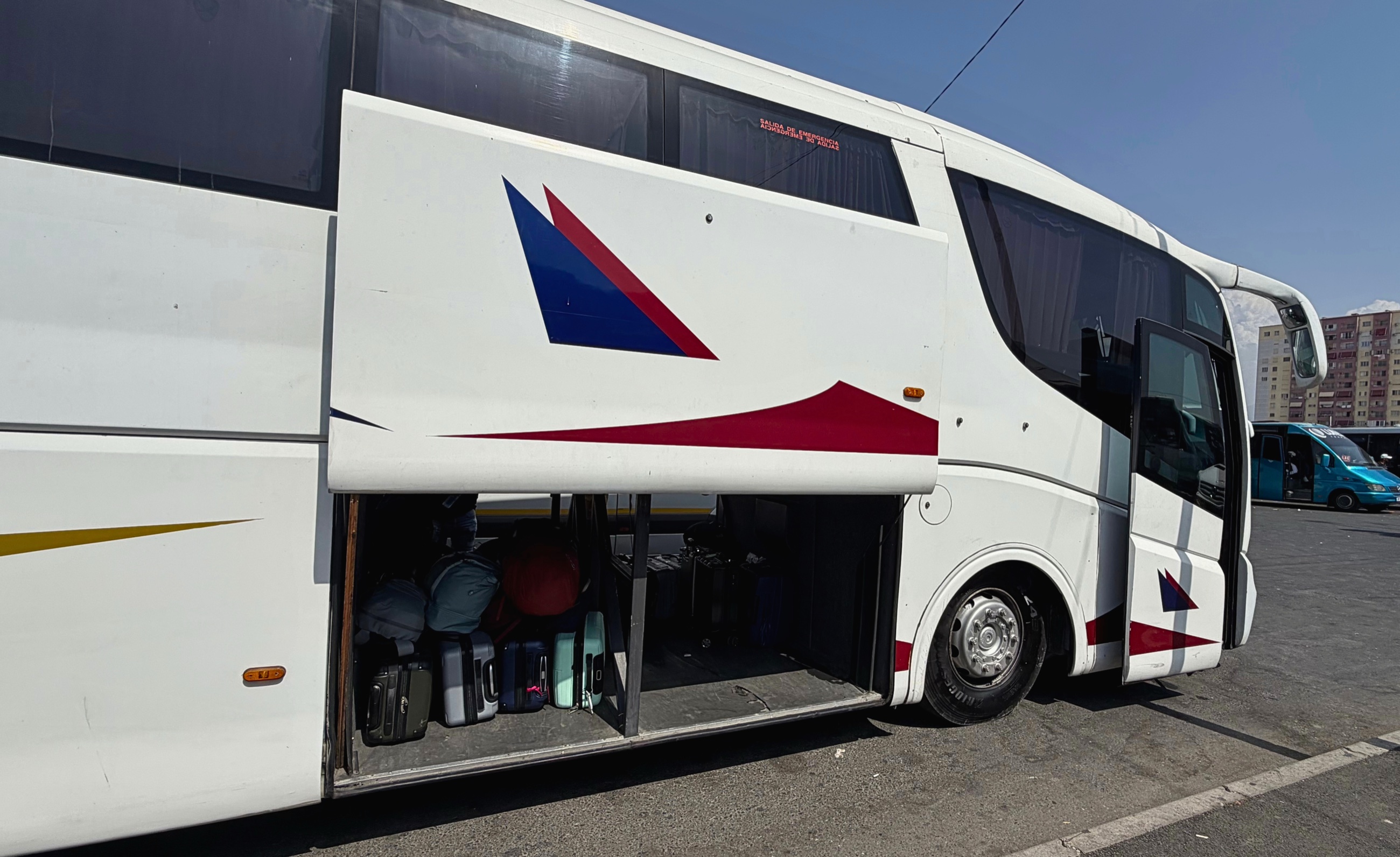 Luggage being loaded beneath an intercity bus on moving day from Tirana to Sarandë.