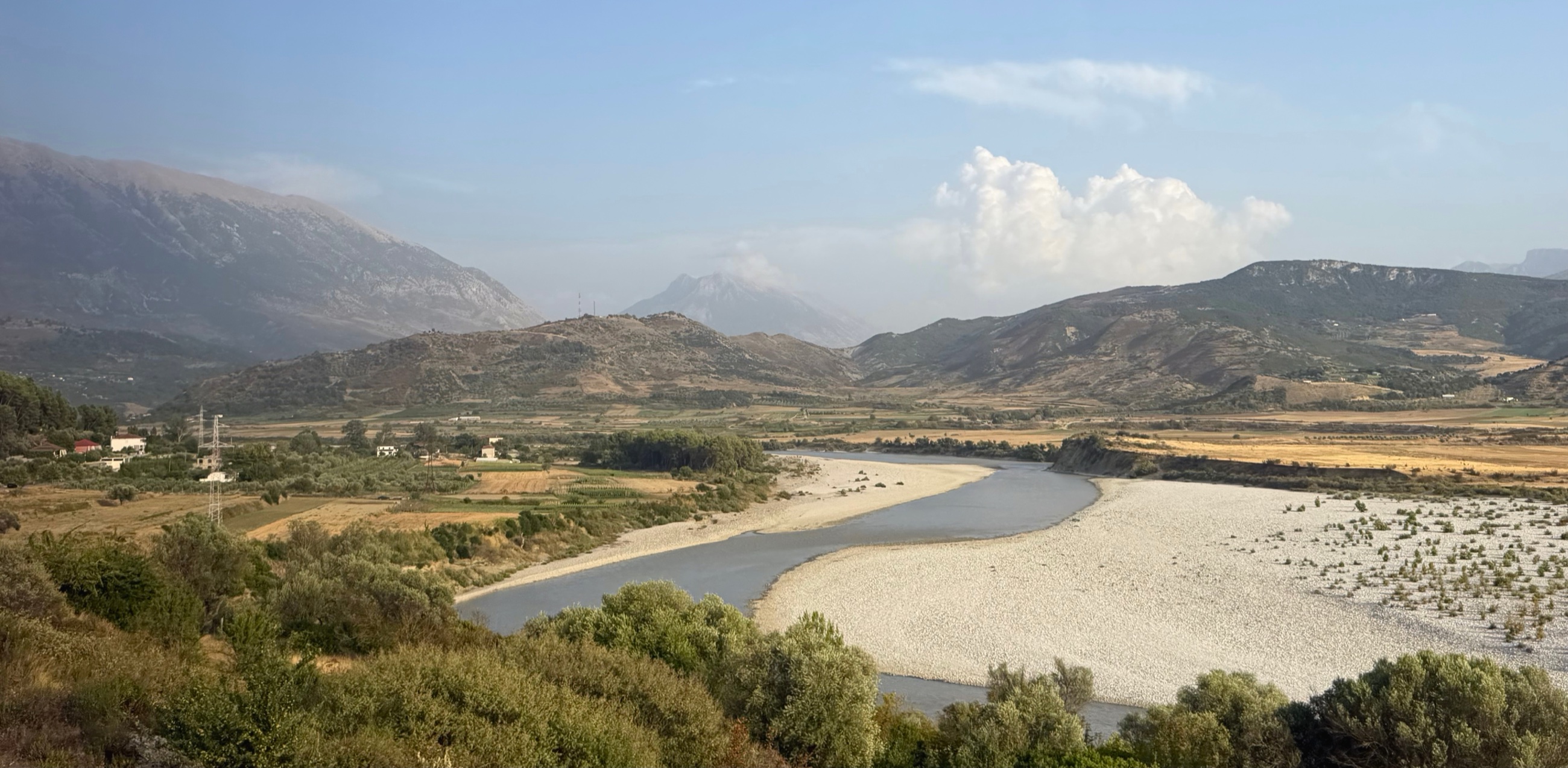 Riverbeds, cultivated valleys, and mountains along the road south through Albania.