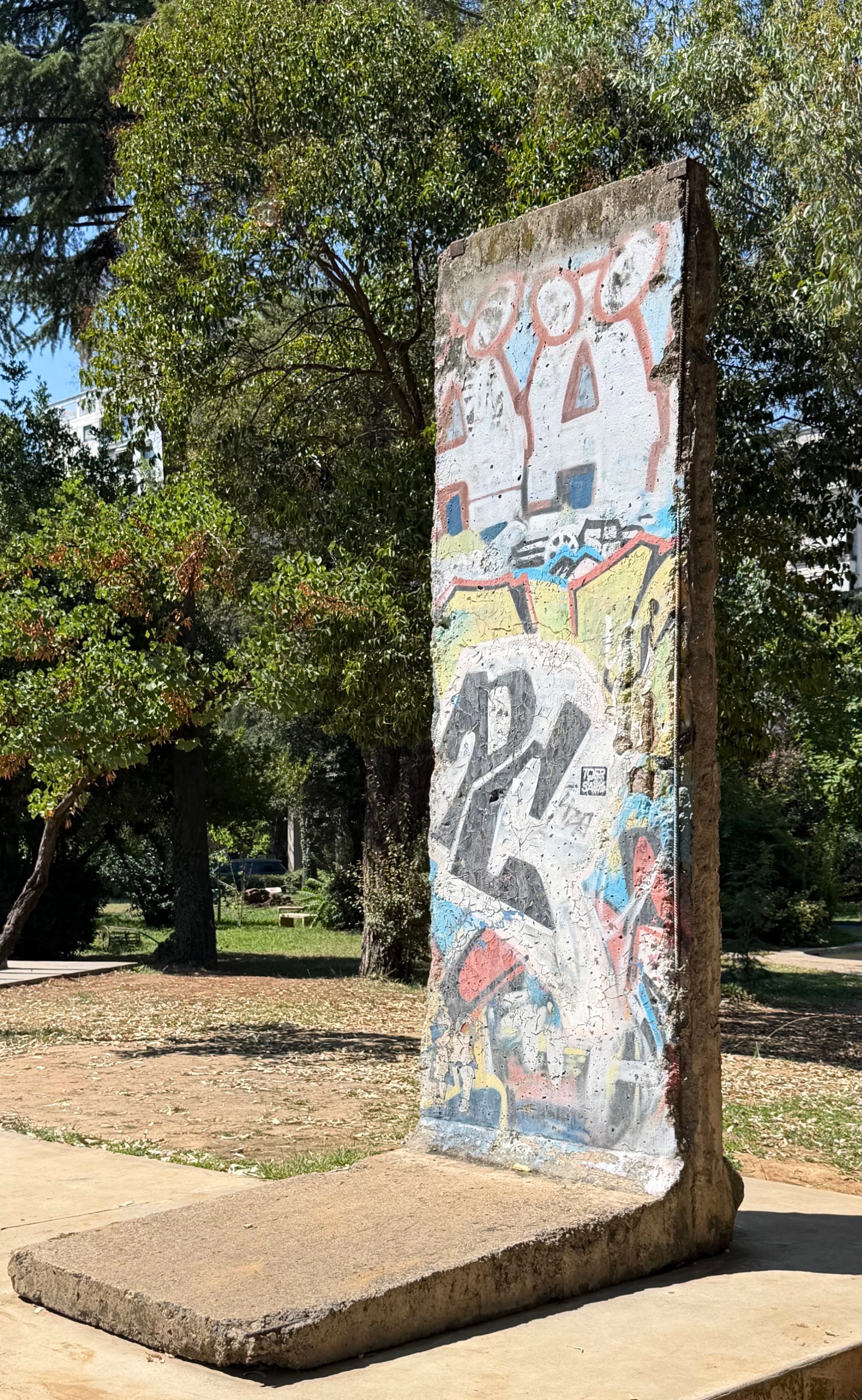 A section of the Berlin Wall standing at Postbllok in Tirana.