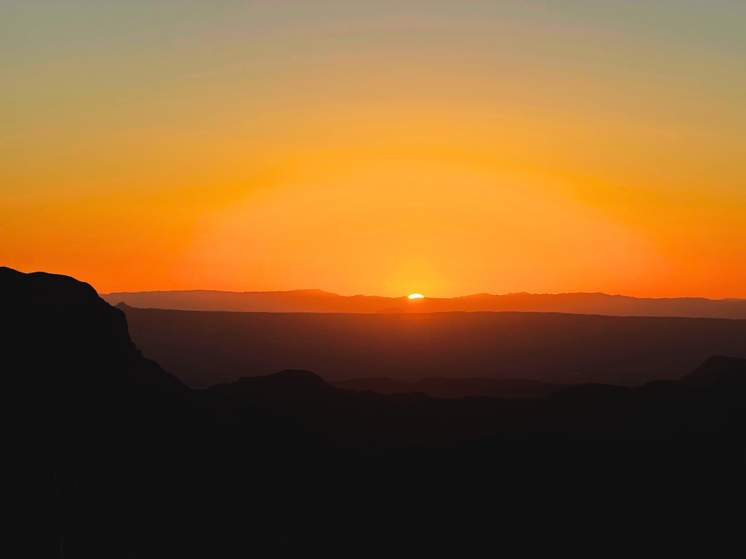 Sunset spreading across the desert and distant mountains at Sotol Vista in Big Bend National Park.