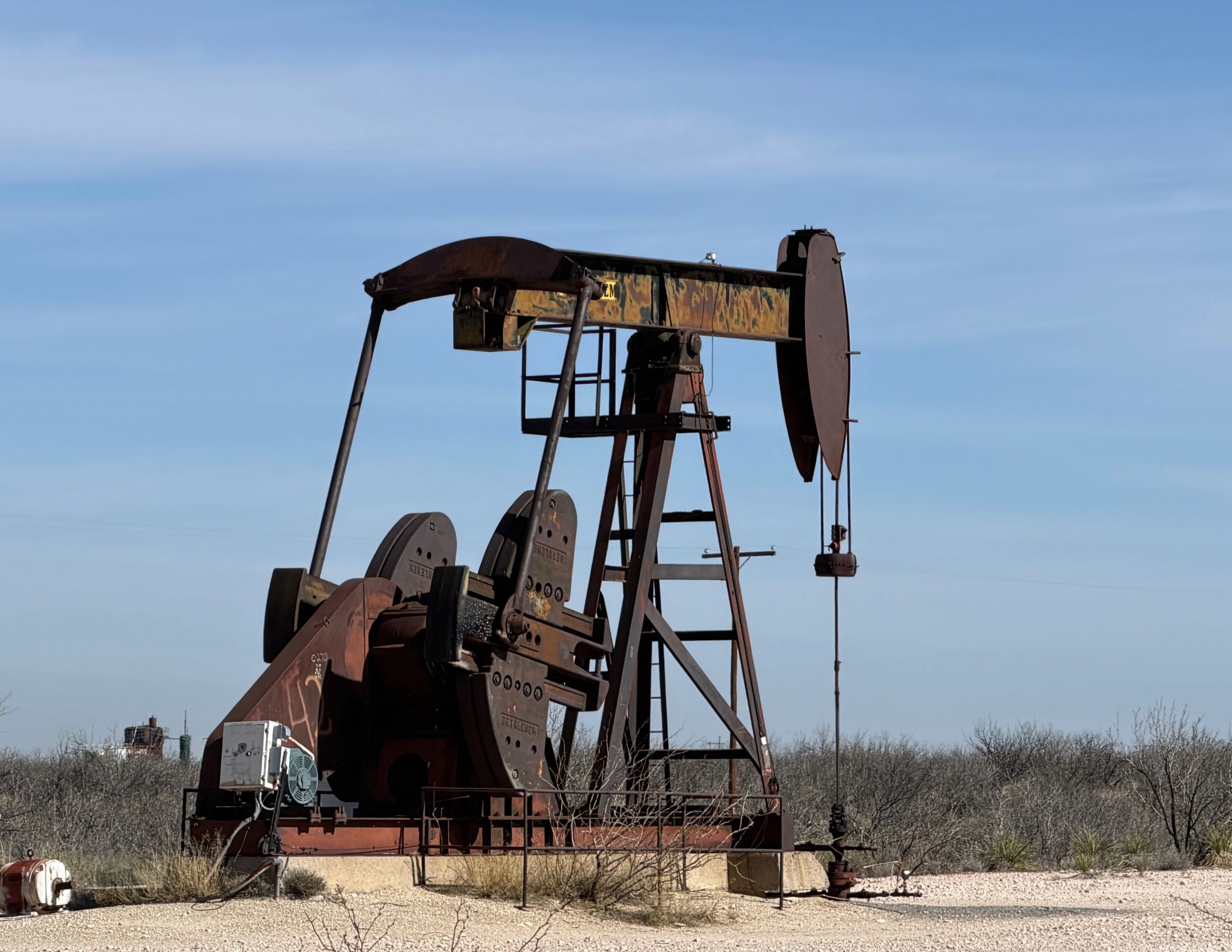 An active pump jack standing in the West Texas landscape.