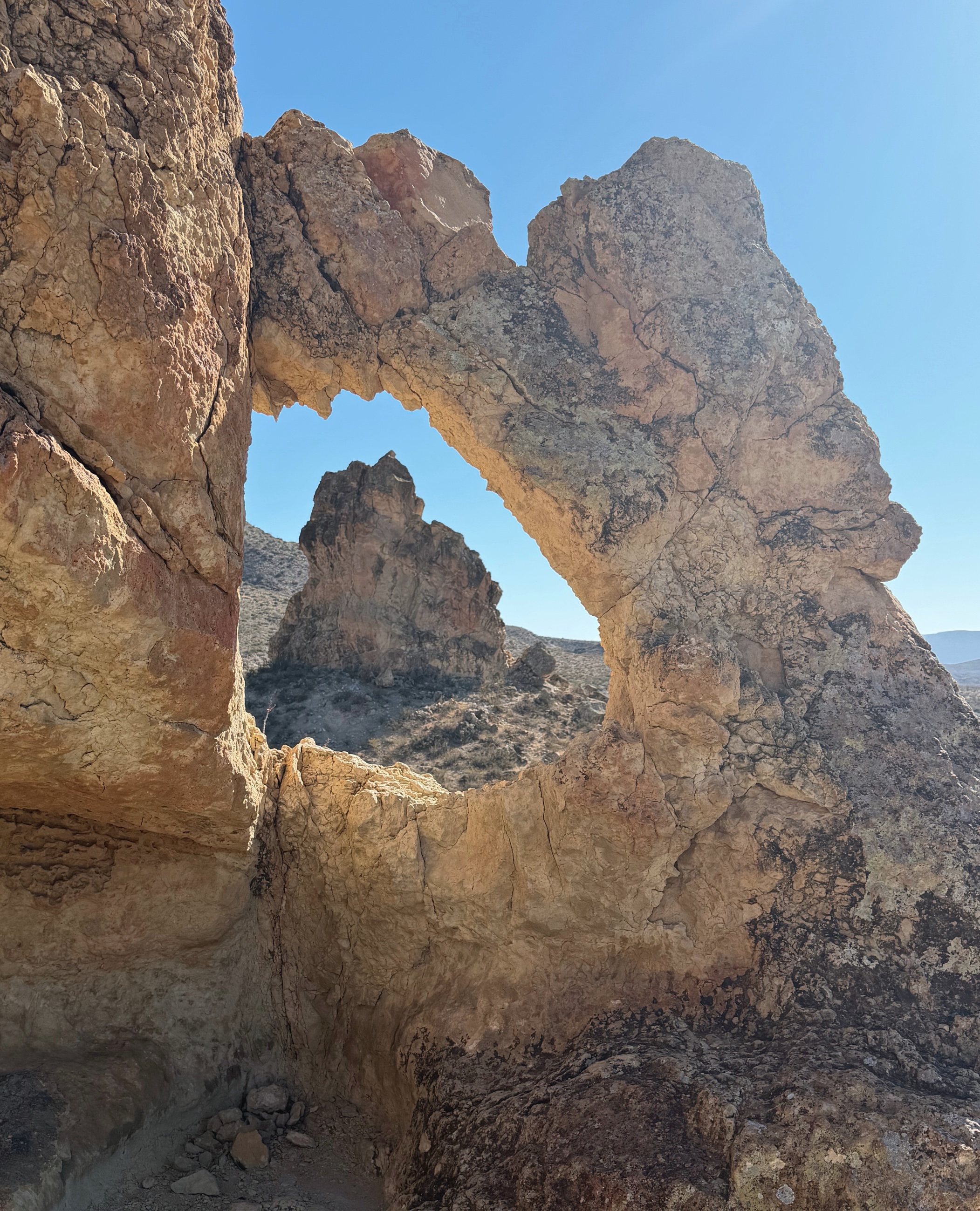 A limestone arch formed by erosion in the desert terrain of Big Bend National Park.