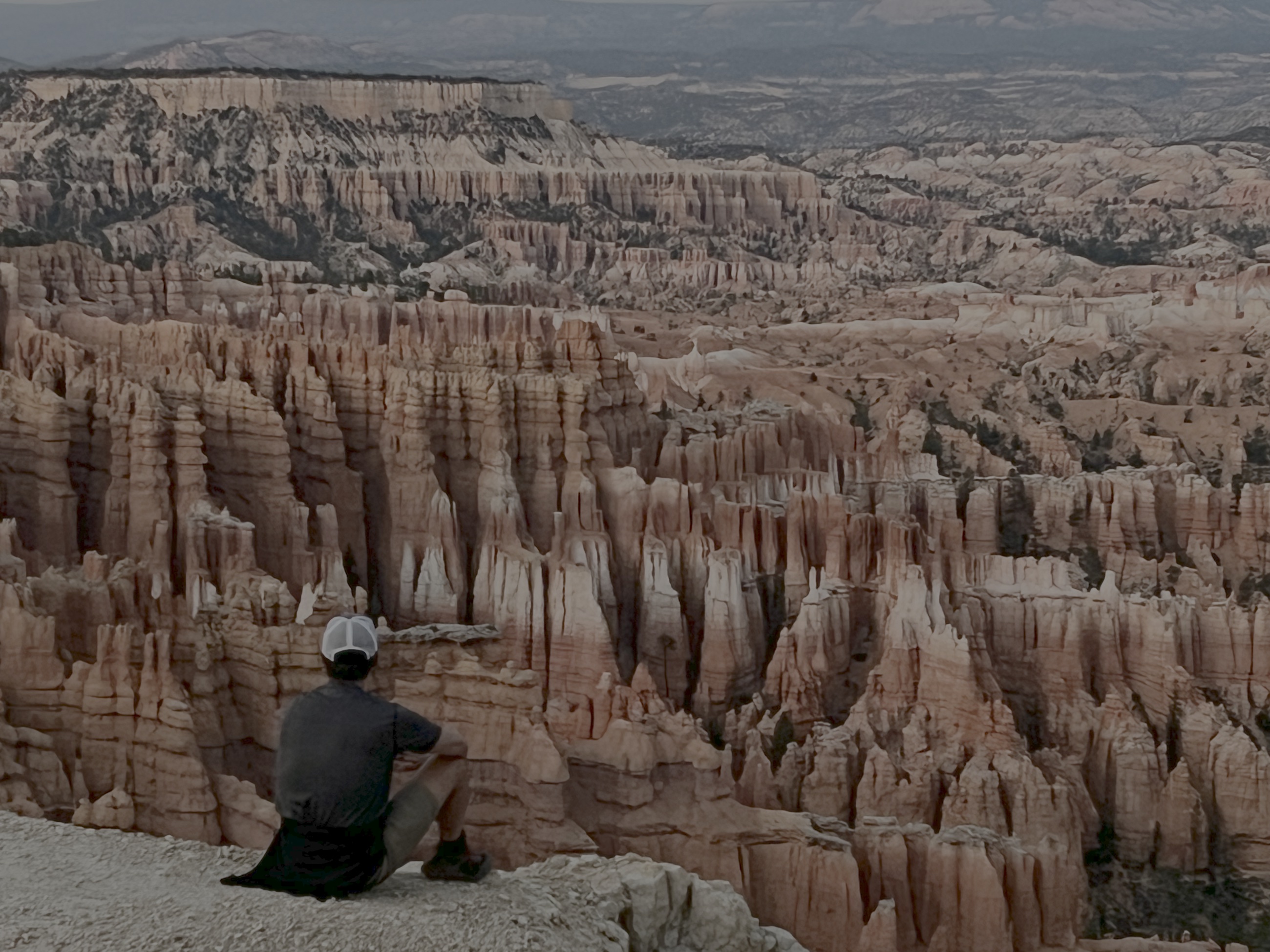 Sam sitting above Bryce Canyon Amphitheater at dusk.