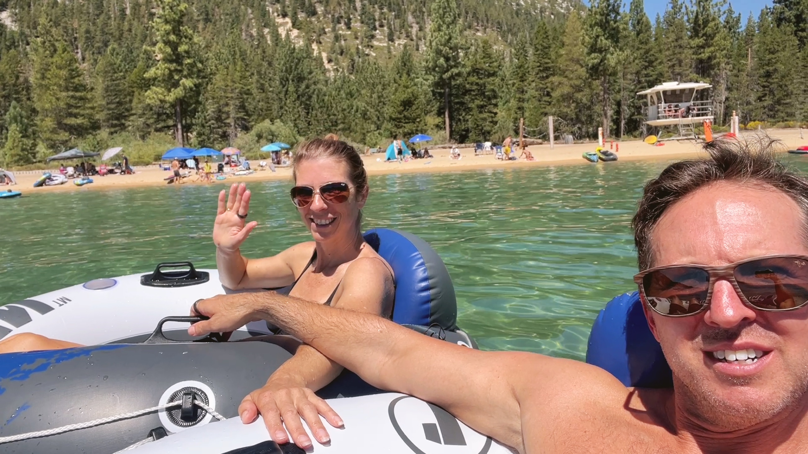 Sam and Stephanie floating in clear blue water at Lake Tahoe near Sand Harbor.