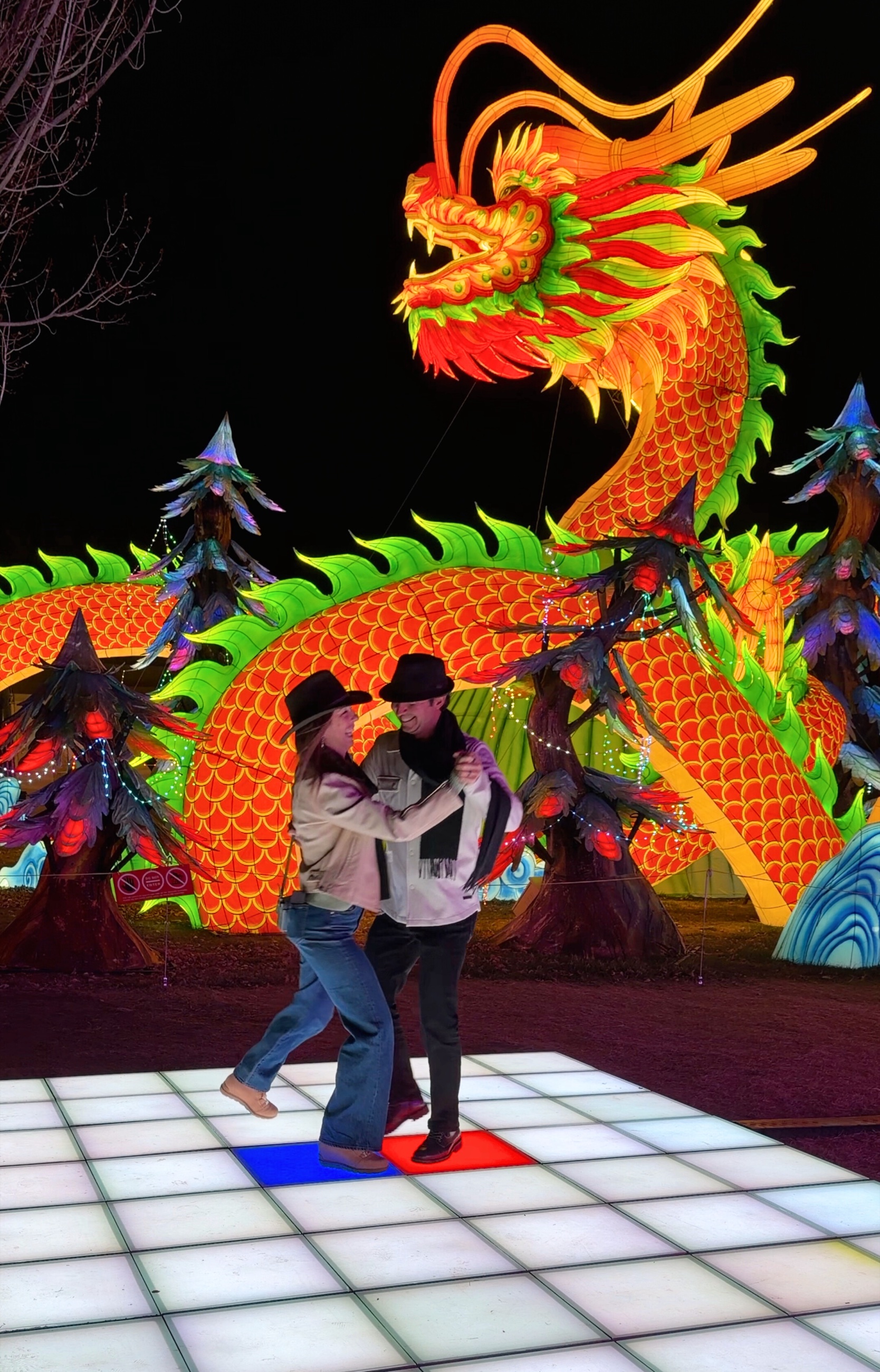 Sam and Stephanie dancing on an illuminated floor beneath a large Chinese dragon lantern.
