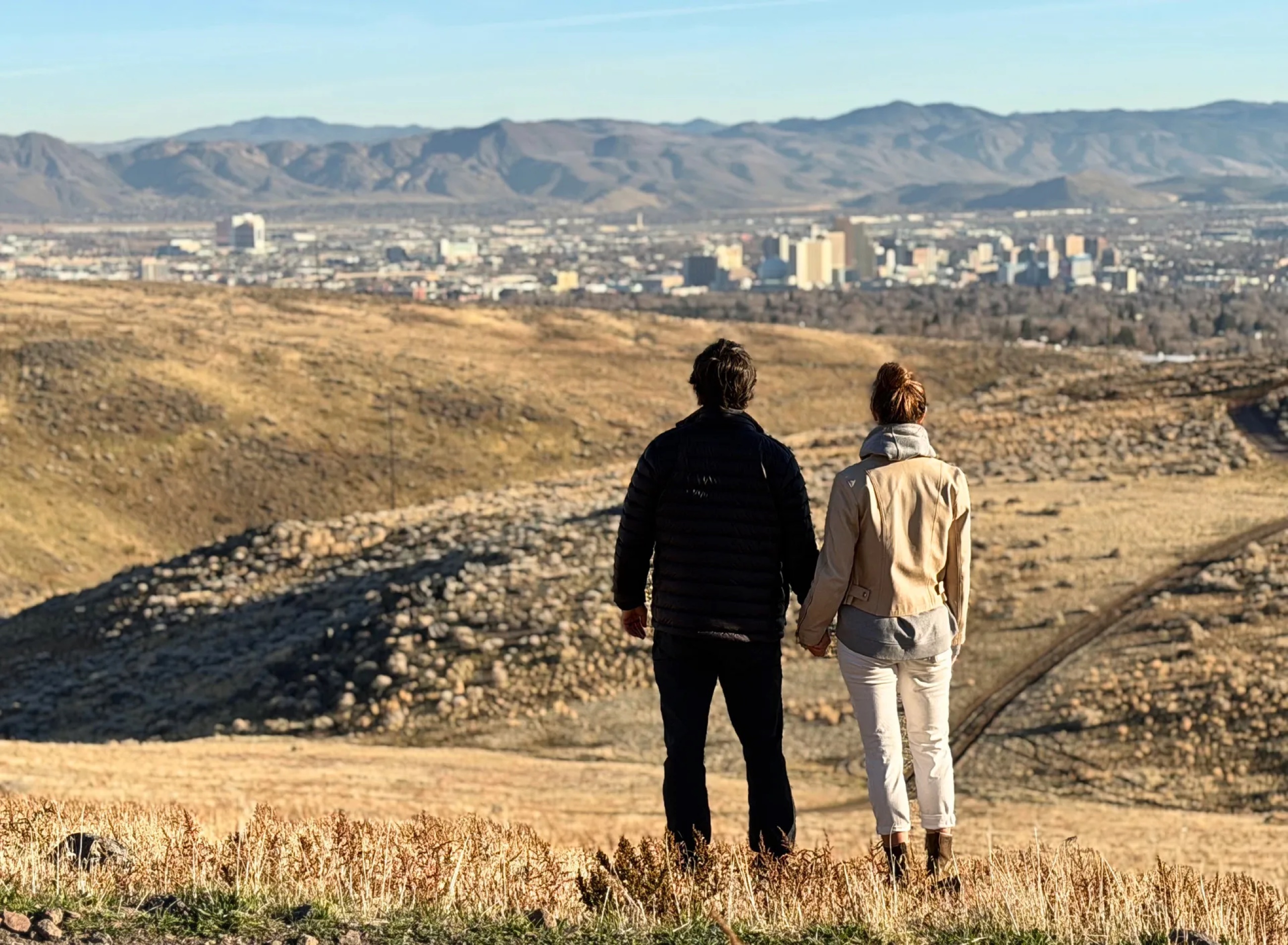 Sam and Stephanie standing together on a foothill ridge overlooking Reno.