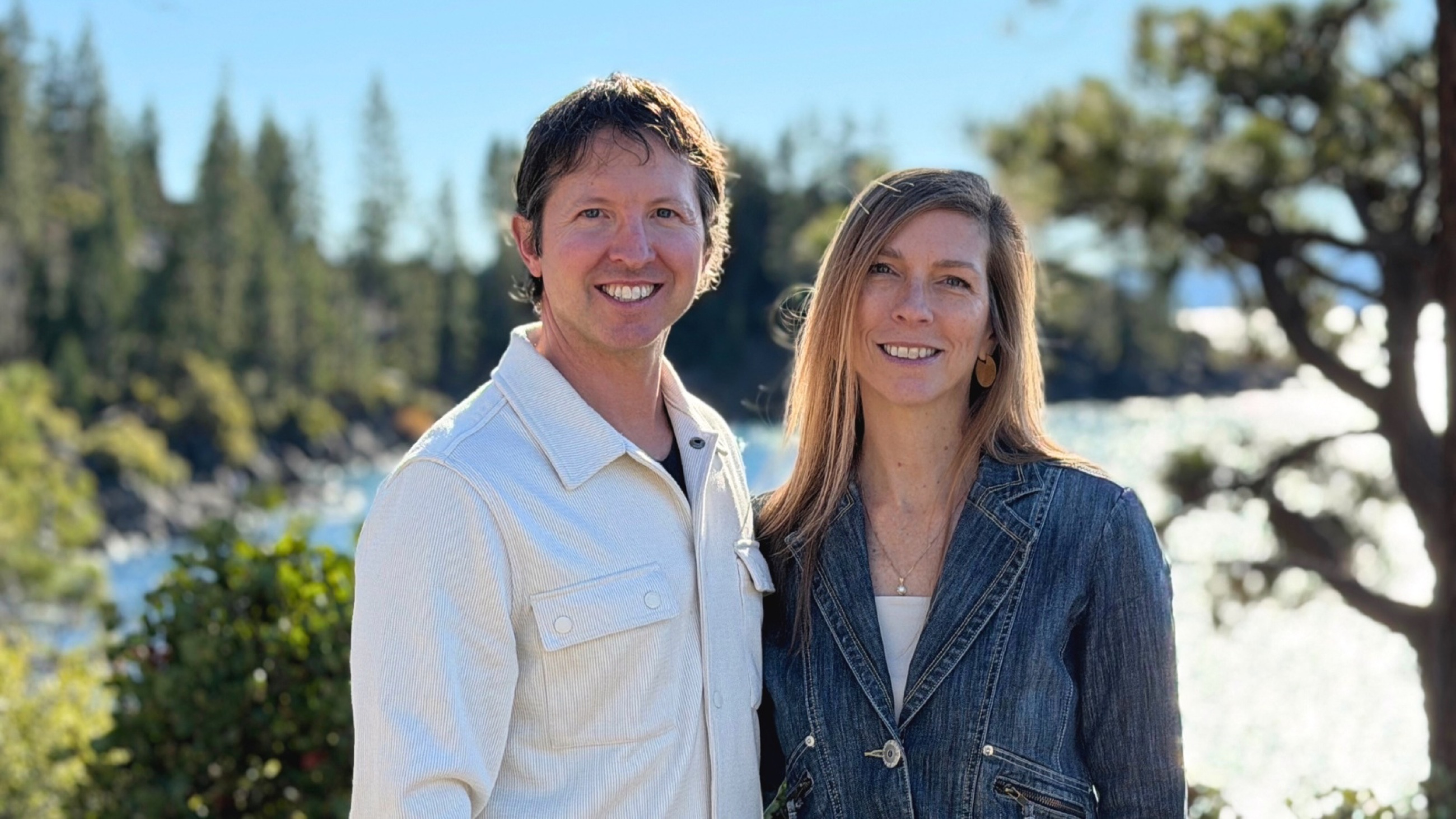 Sam and Stephanie standing together at Sand Harbor with Lake Tahoe behind them.