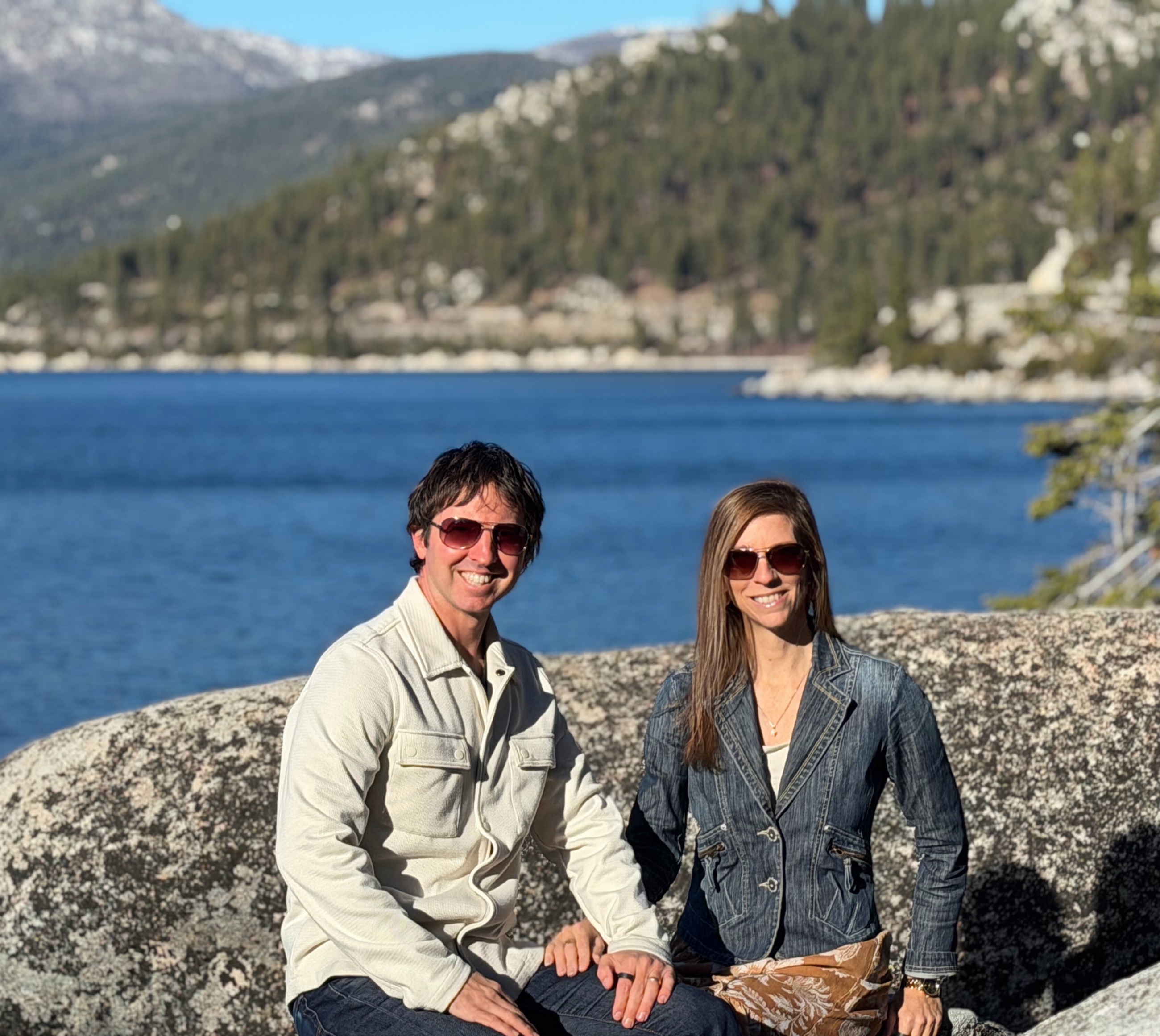 Sam and Stephanie seated together on granite above Lake Tahoe.