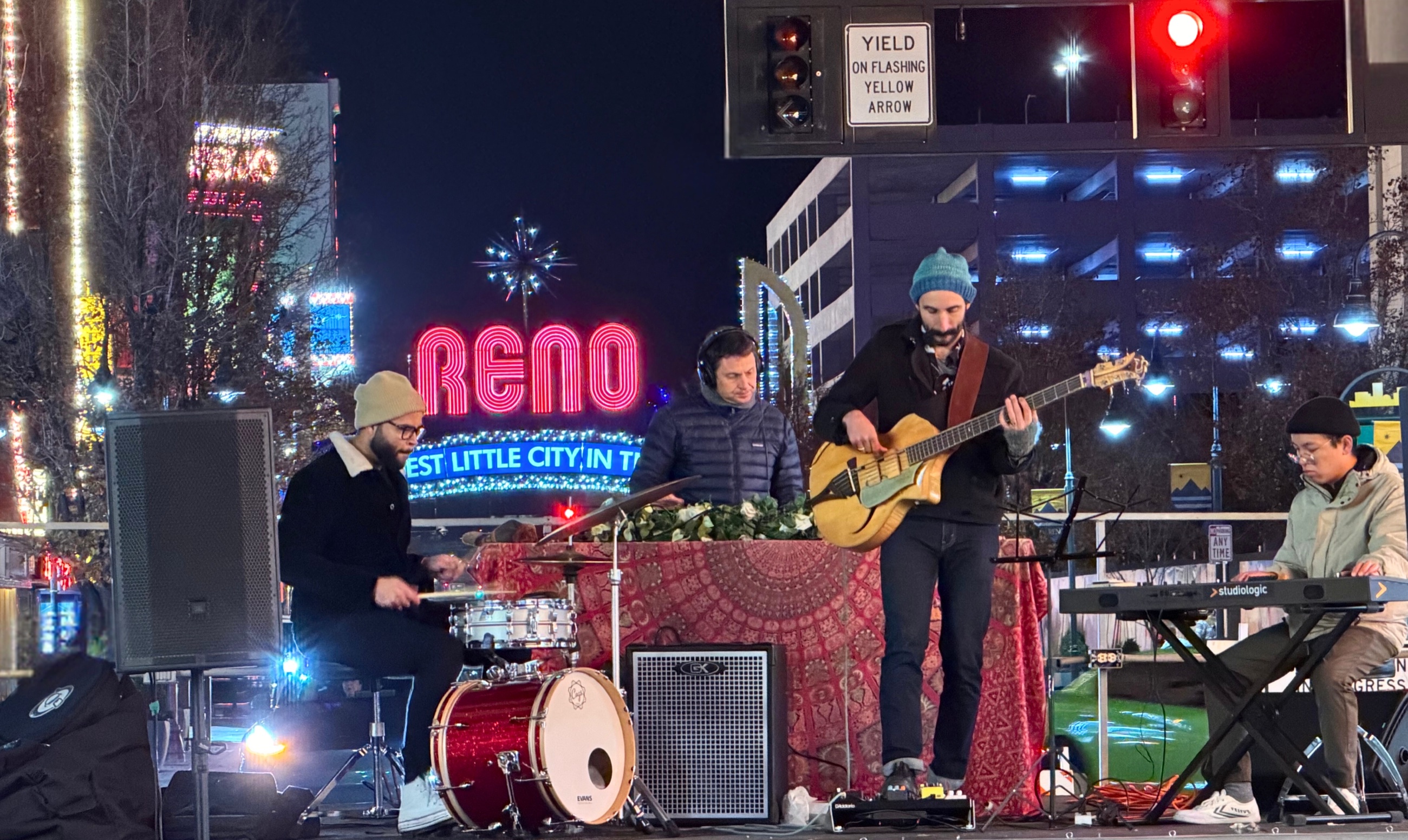 A local band performing outdoors near the illuminated Reno Arch.