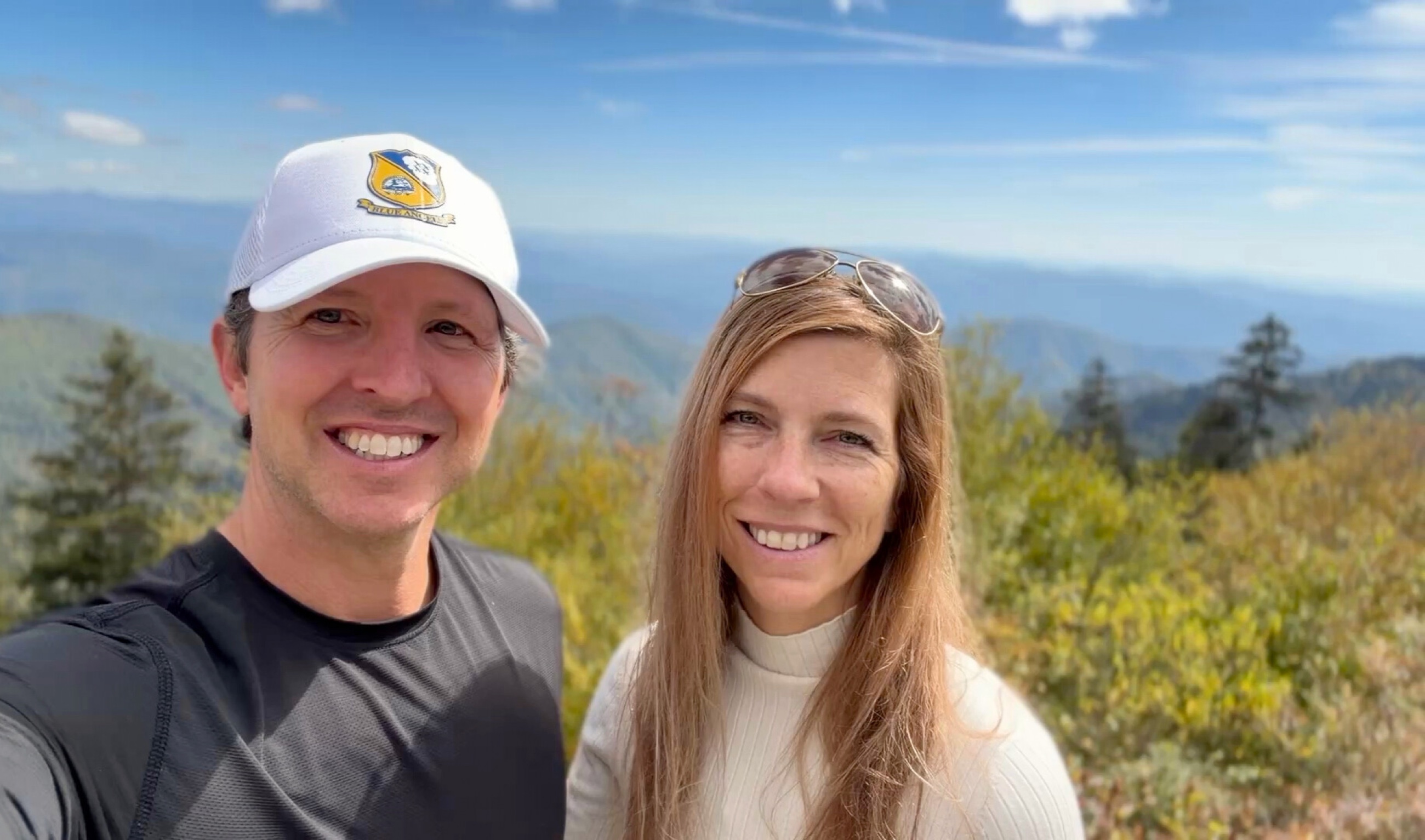 Sam and Stephanie standing together in Great Smoky Mountains National Park with mountain ridges behind them.