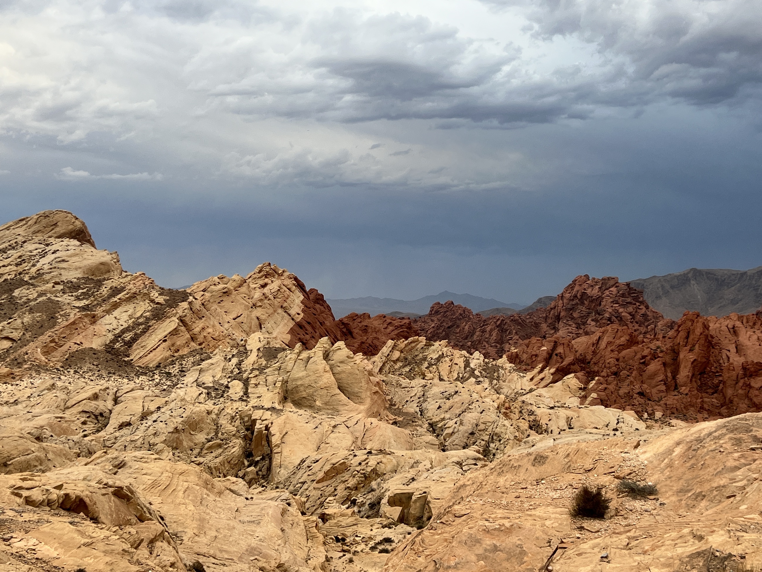 Layered sandstone ridges beneath storm-streaked skies in Valley of Fire.