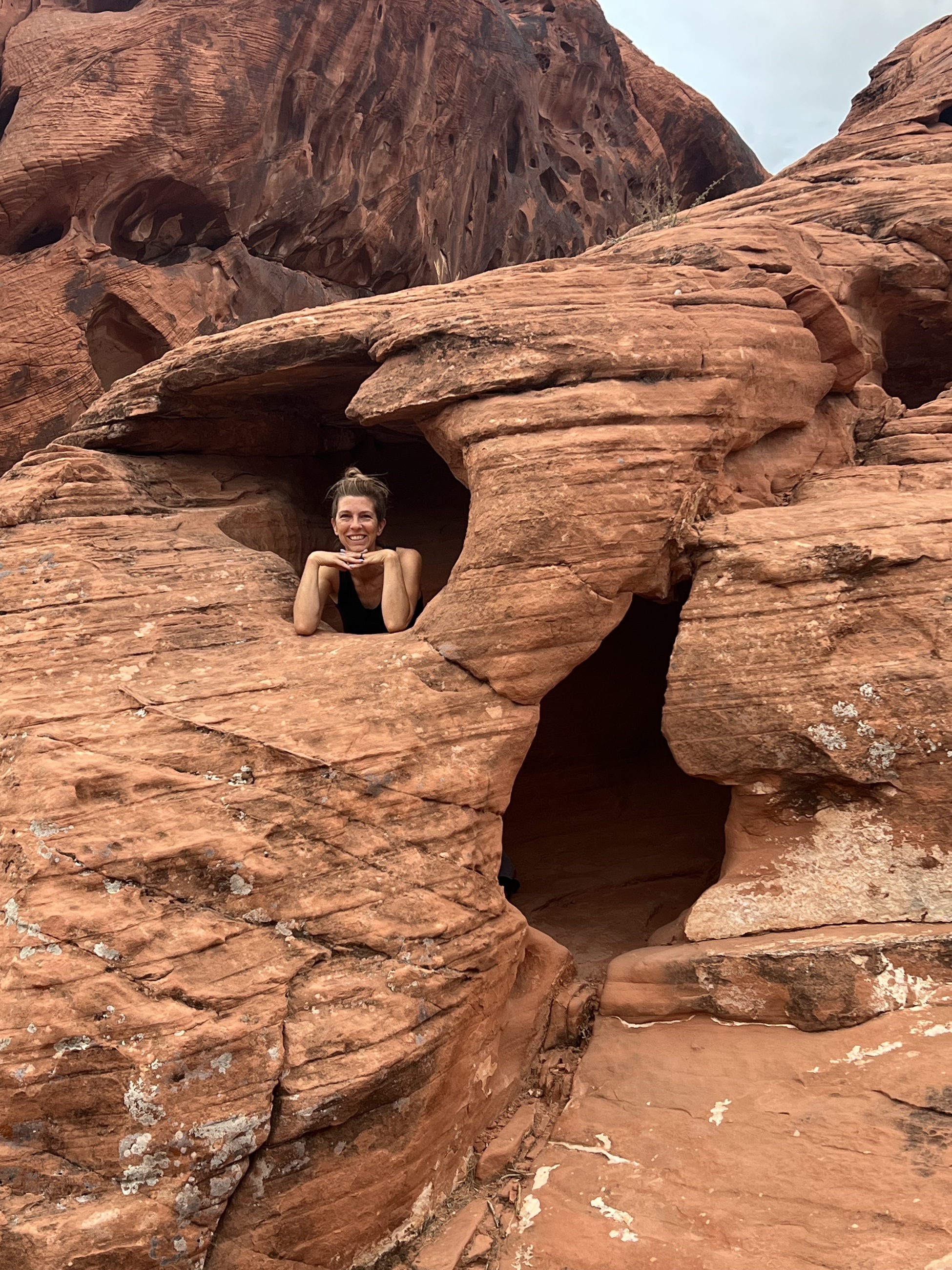 A person partially hidden among red sandstone formations in Valley of Fire.